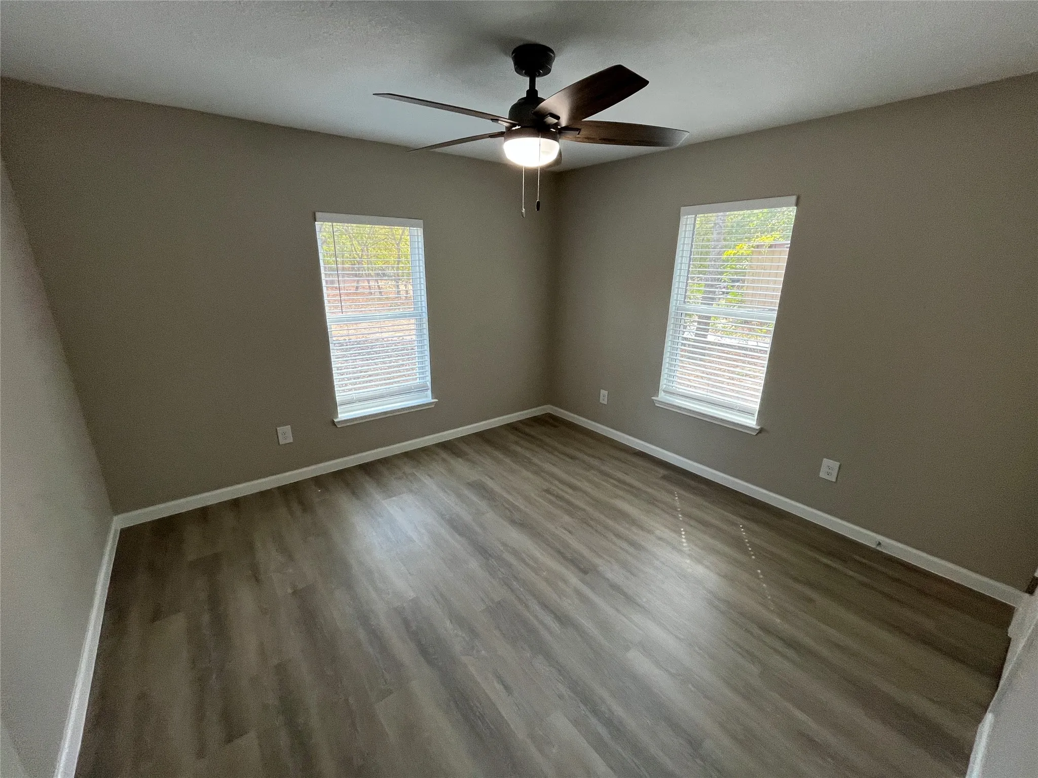 Wood-finish flooring with white trim and neutral wall paint