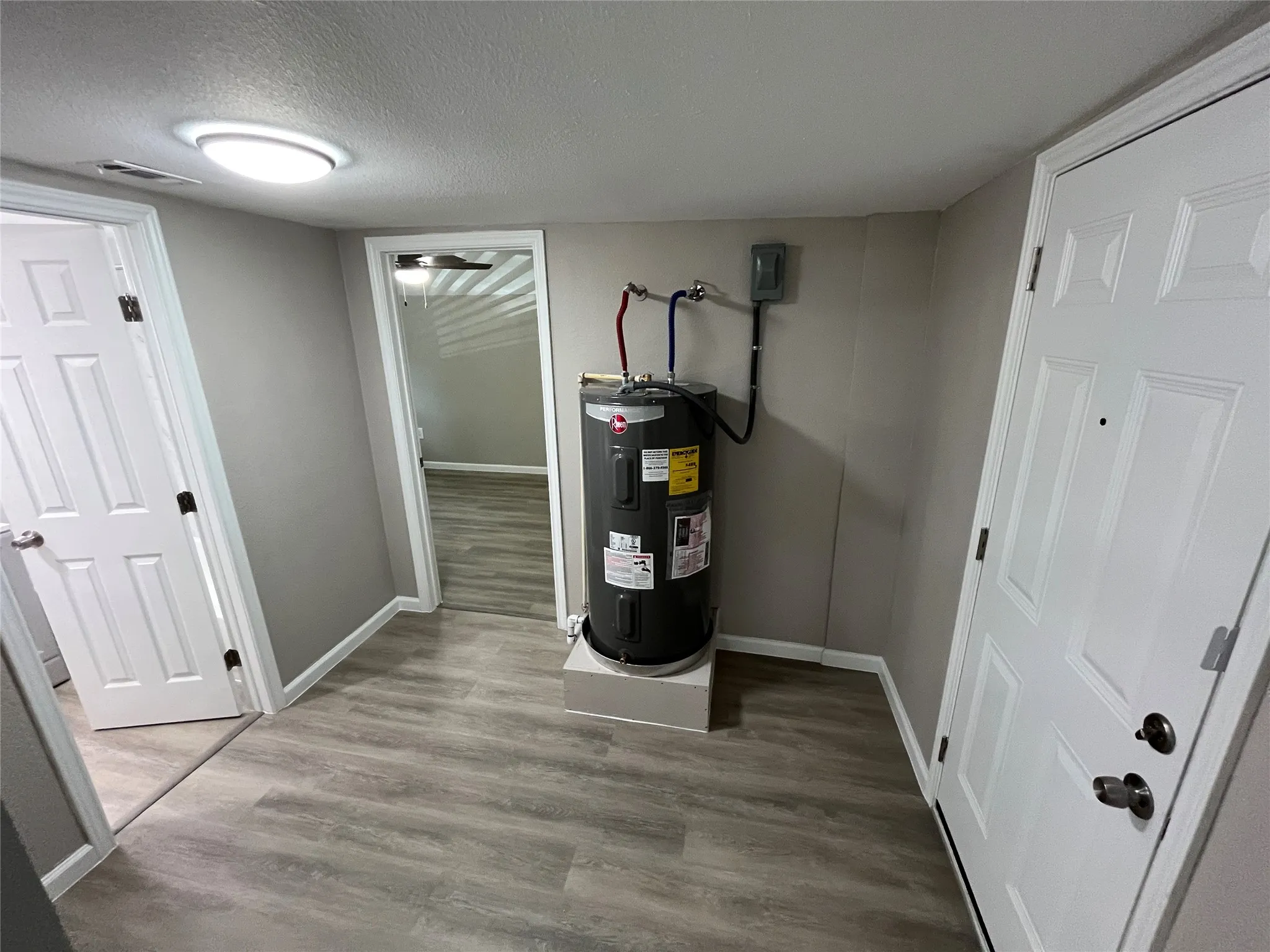 Neutral gray wall paint with white trim, wood-finish flooring, and a modern ceiling light fixture