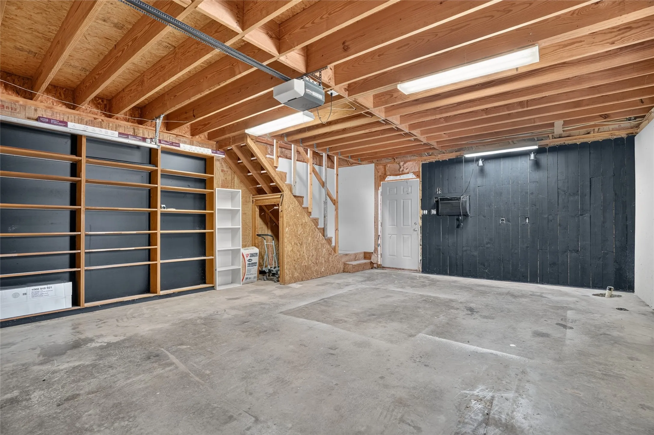 Exposed wood beam ceiling, concrete flooring, built-in shelving, and white paneled door