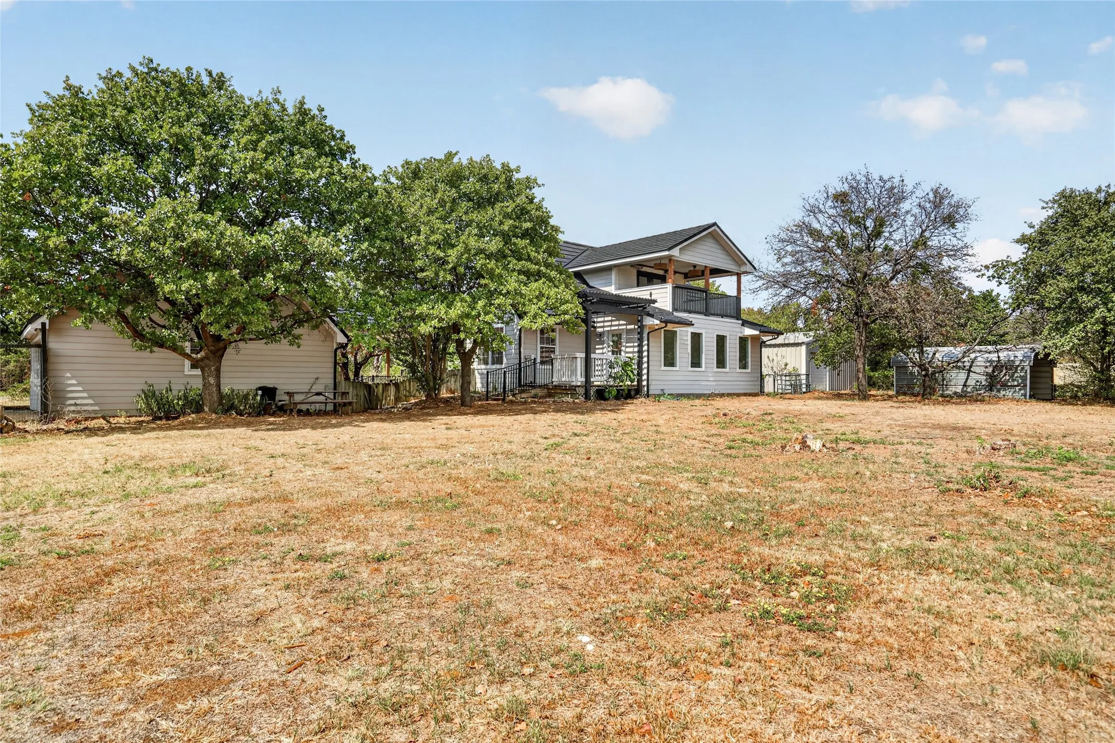 Extensive property with a two-story home, balcony, and detached outbuilding
