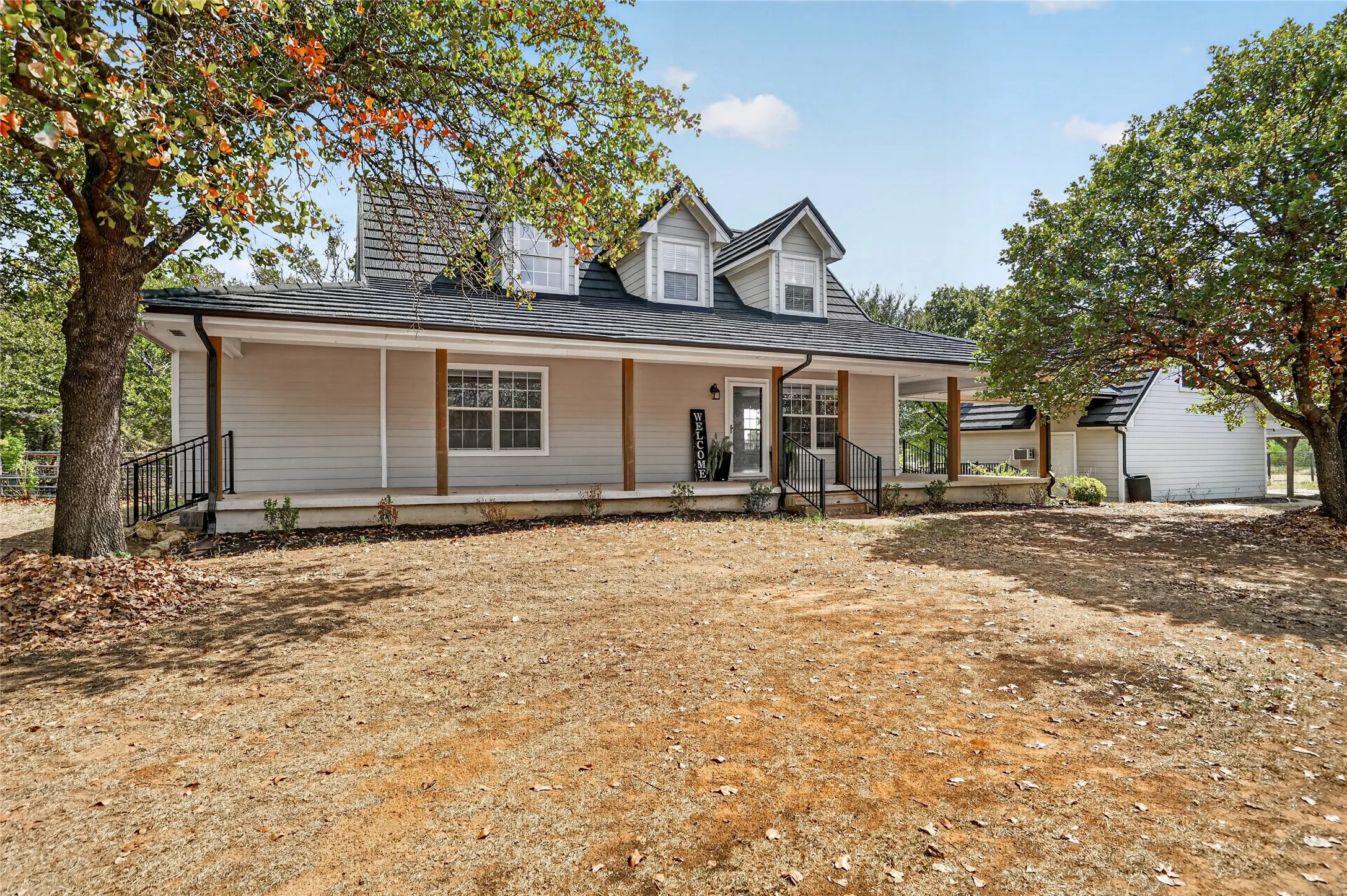 Two-story residence with dormer windows and a covered front porch featuring wood-clad columns