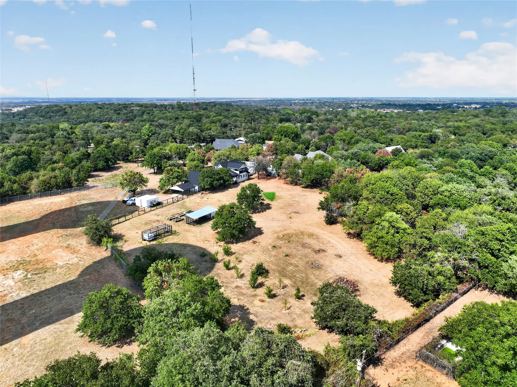 Expansive treed lot with a fenced perimeter and a detached outbuilding