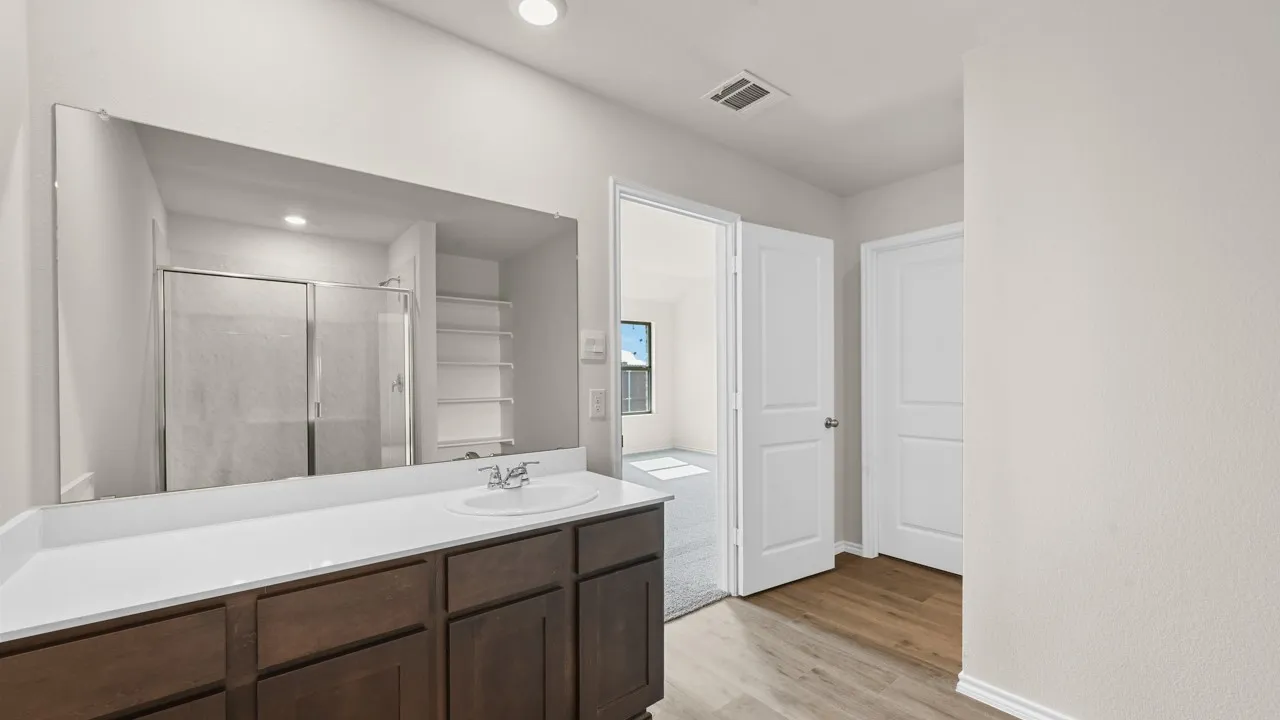 Built-in vanity with a single basin sink, extensive countertop space, and wood-finish cabinetry
