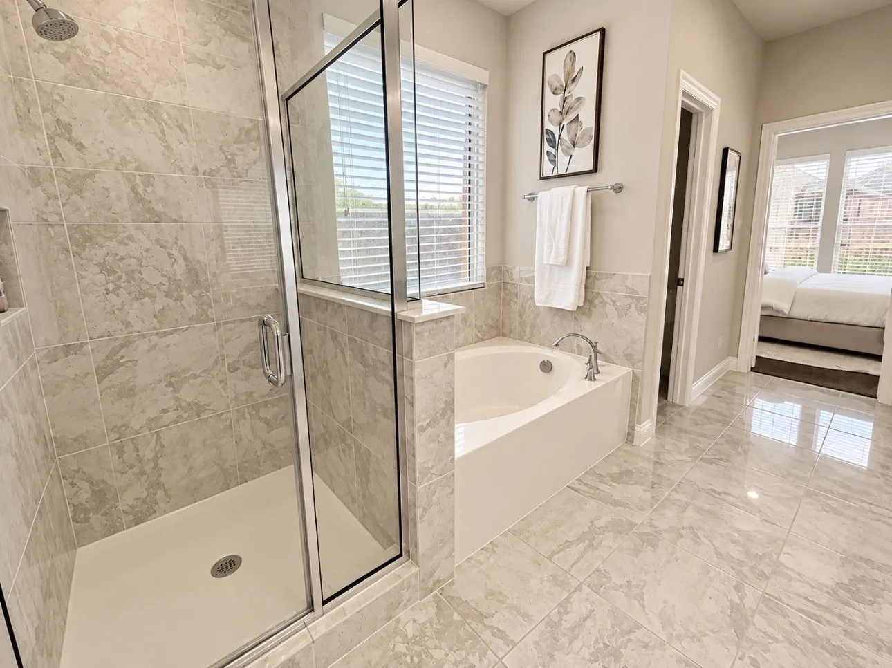 Tiled bathroom with a glass-enclosed shower, built-in shower niche, and a corner soaking tub