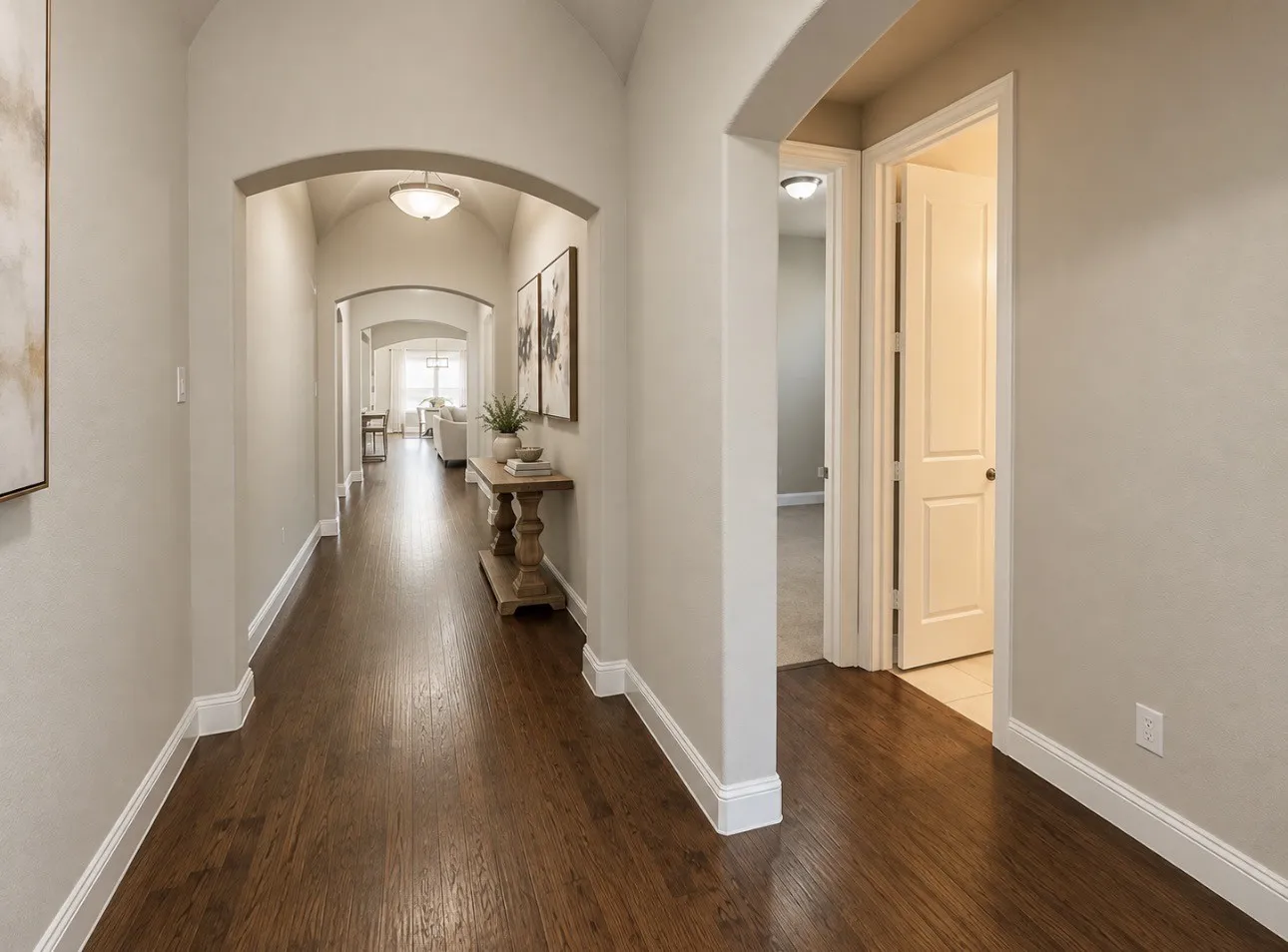 Archway entry with wood-finish flooring, recessed ceiling lighting, and panel interior doors