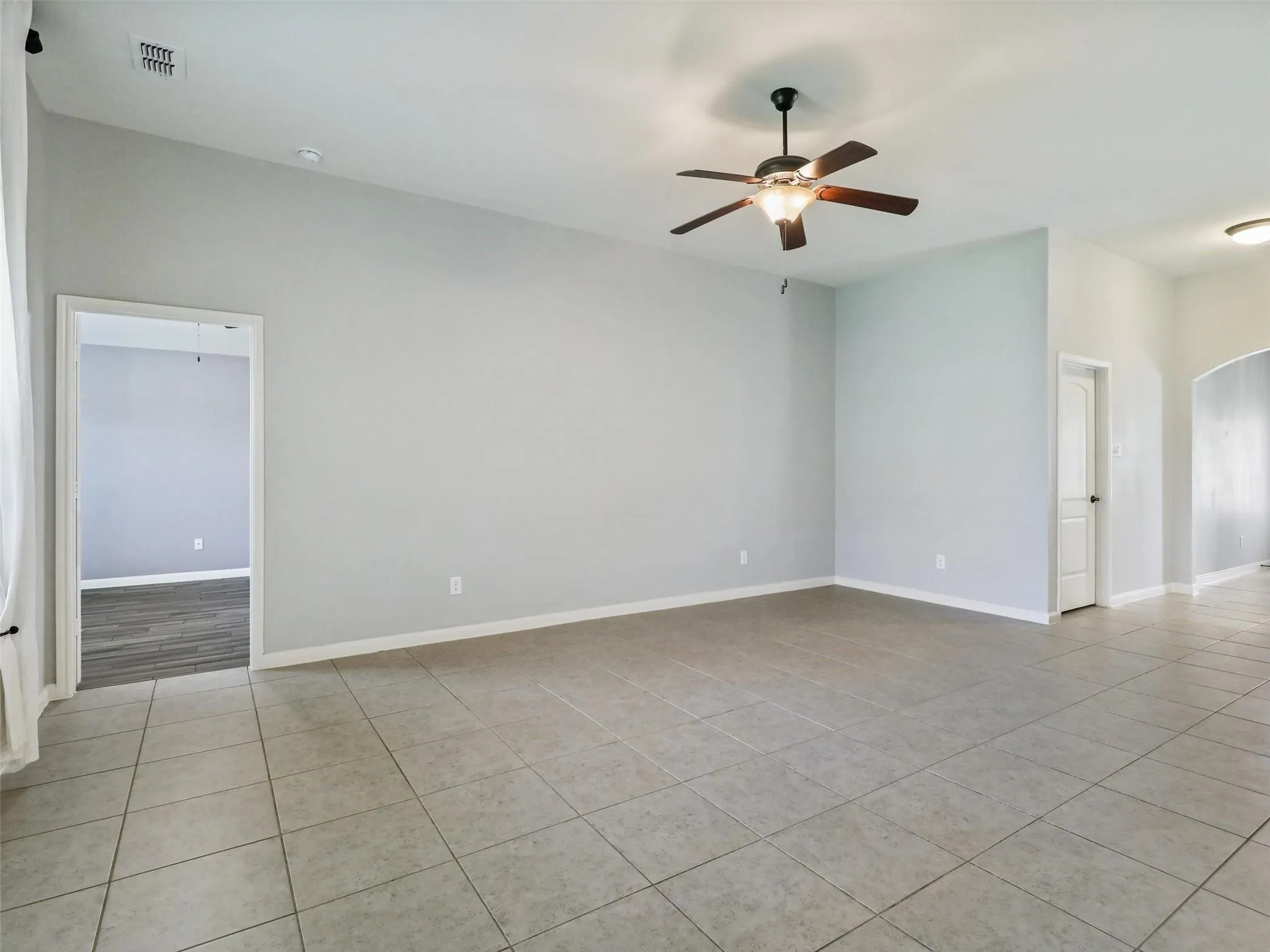 Light gray wall paint, tile flooring, recessed lighting, and a ceiling fan with light fixture