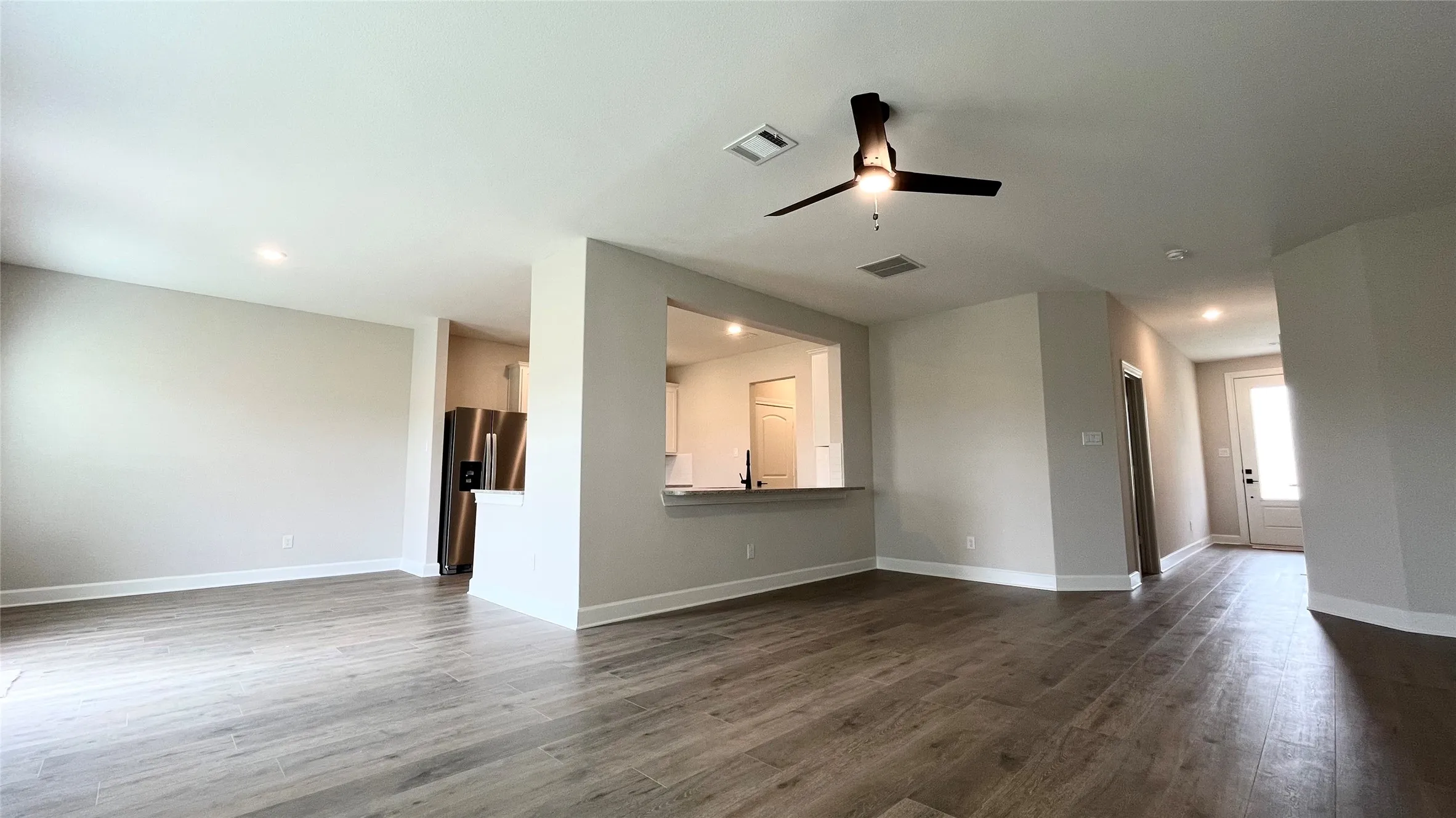 Wood-finish flooring throughout, recessed lighting, and a modern ceiling fan