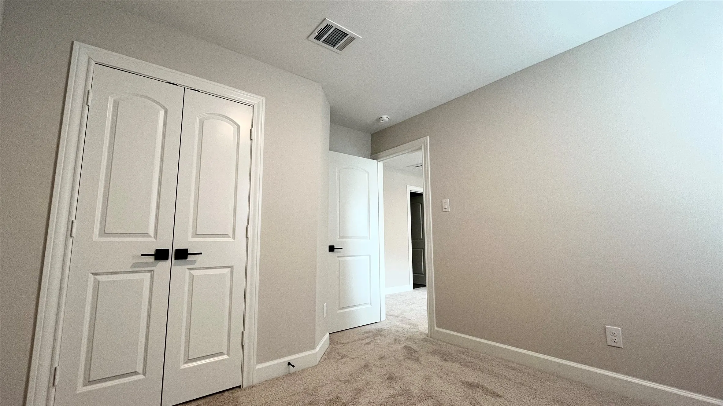 Light-colored carpeting, white baseboards, and neutral wall paint