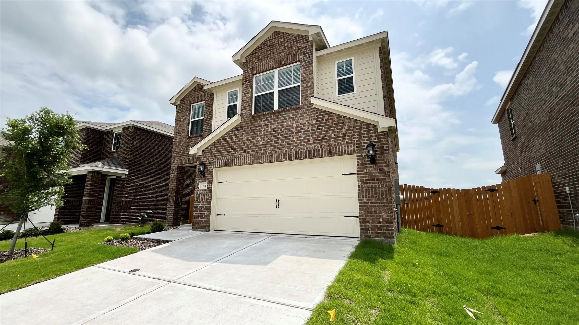 Two-story residence featuring a brick and siding exterior, an attached two-car garage, and a concrete driveway