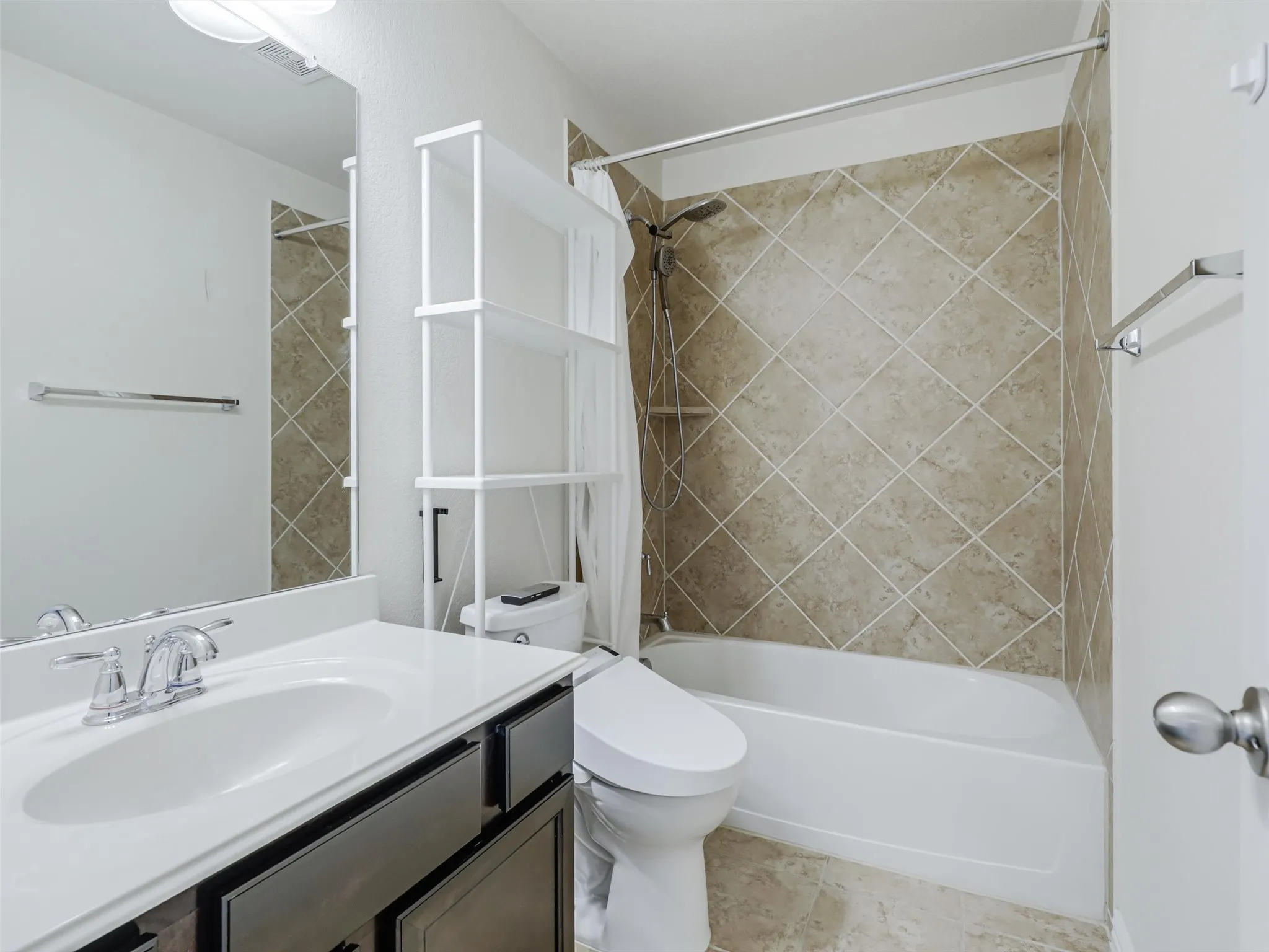 Vanity with integrated sink, chrome faucet, and dark wood-finish cabinetry