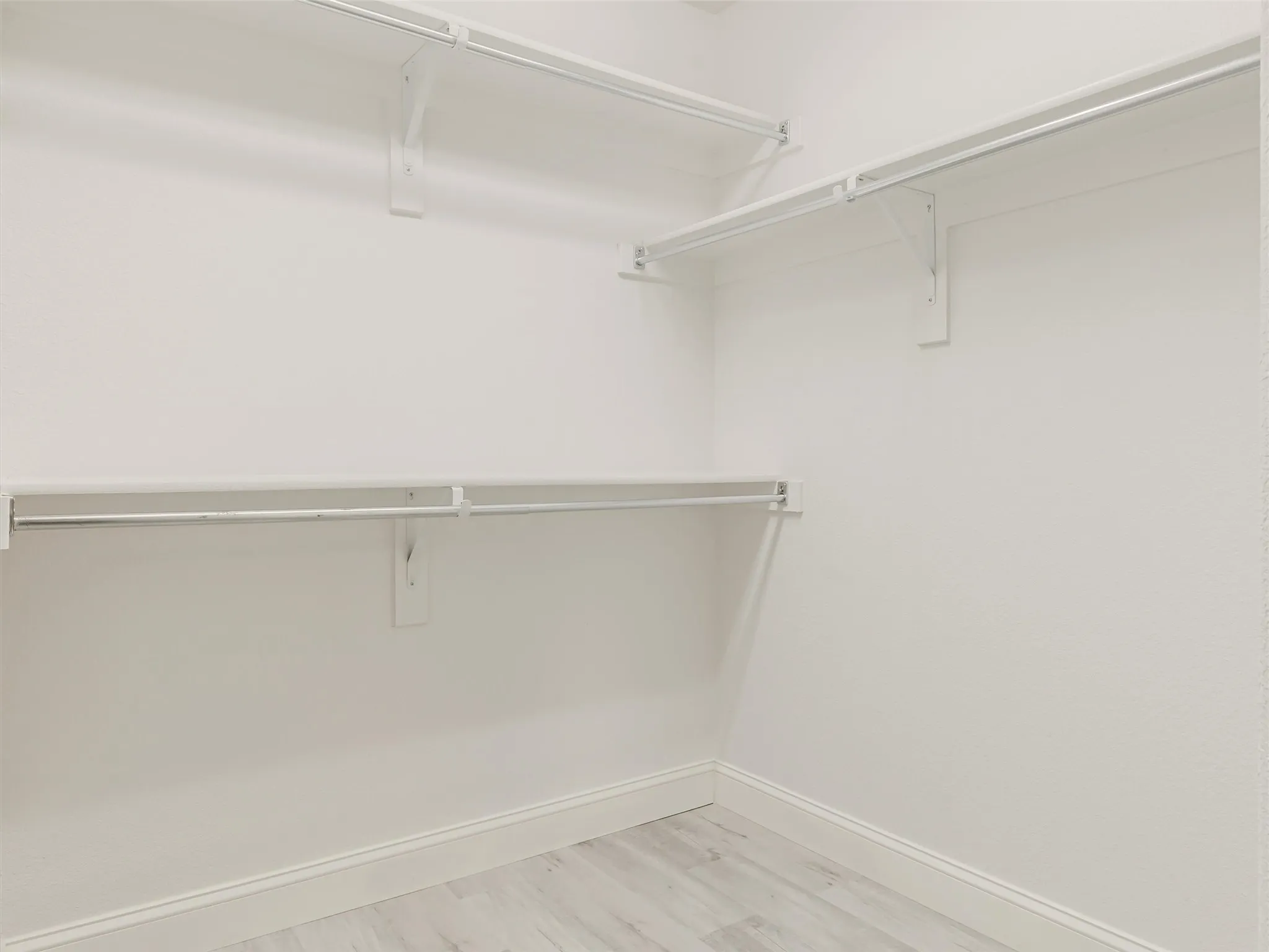 Built-in closet system featuring multiple white shelves and hanging rods