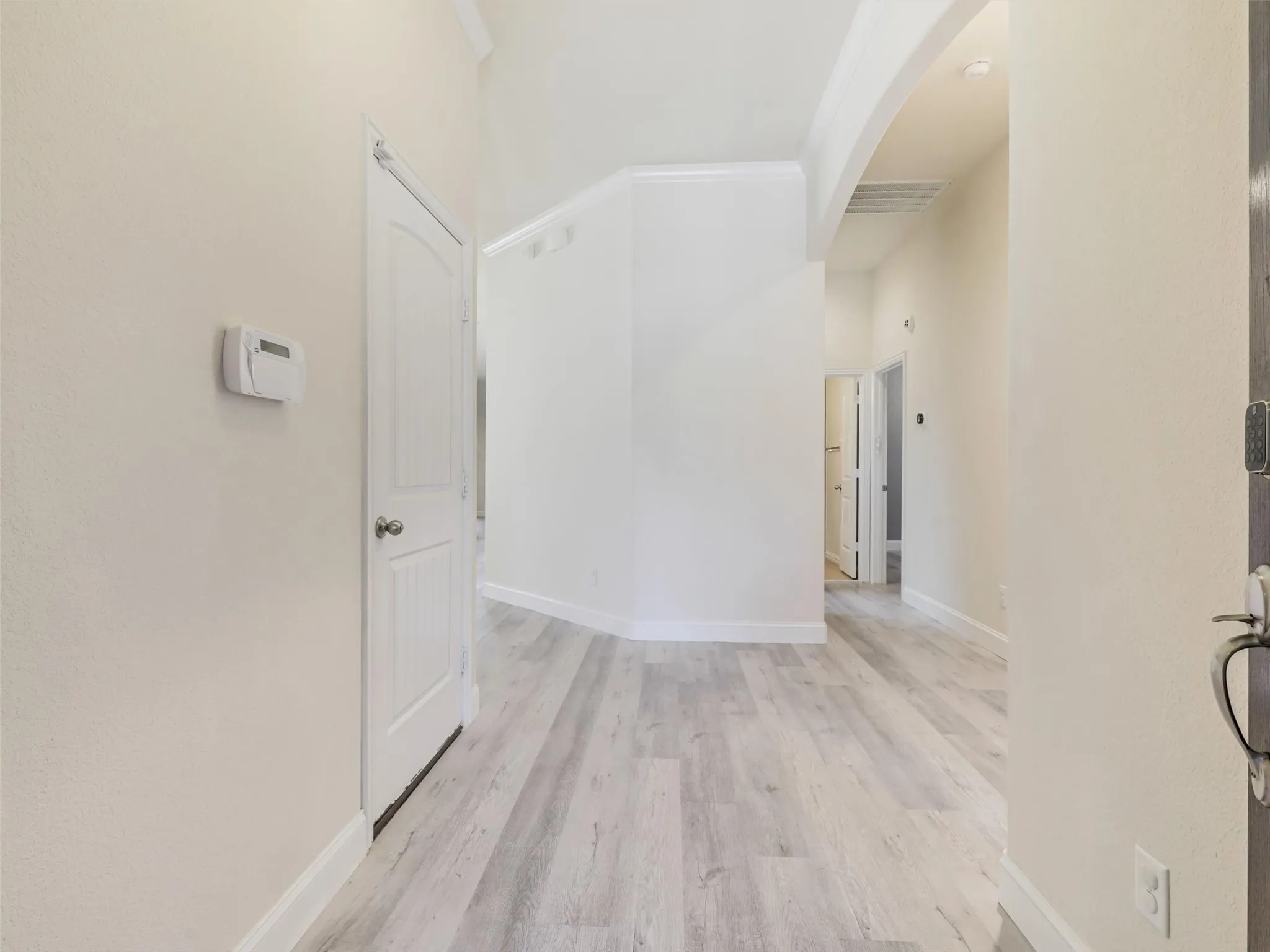 Wood-finish flooring throughout, arched entryway, and white trim accents