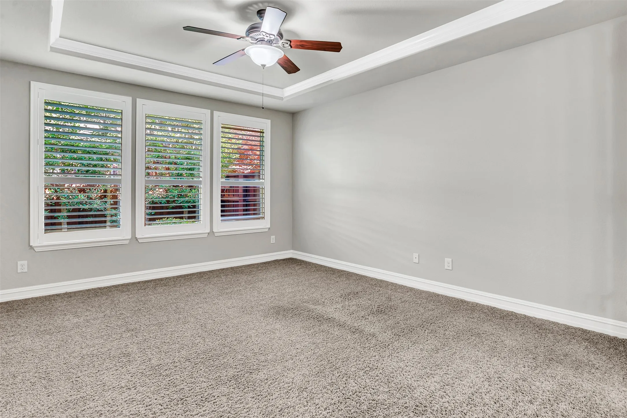 The master suite has Plantation shutters that overlook the backyard and crown molding.