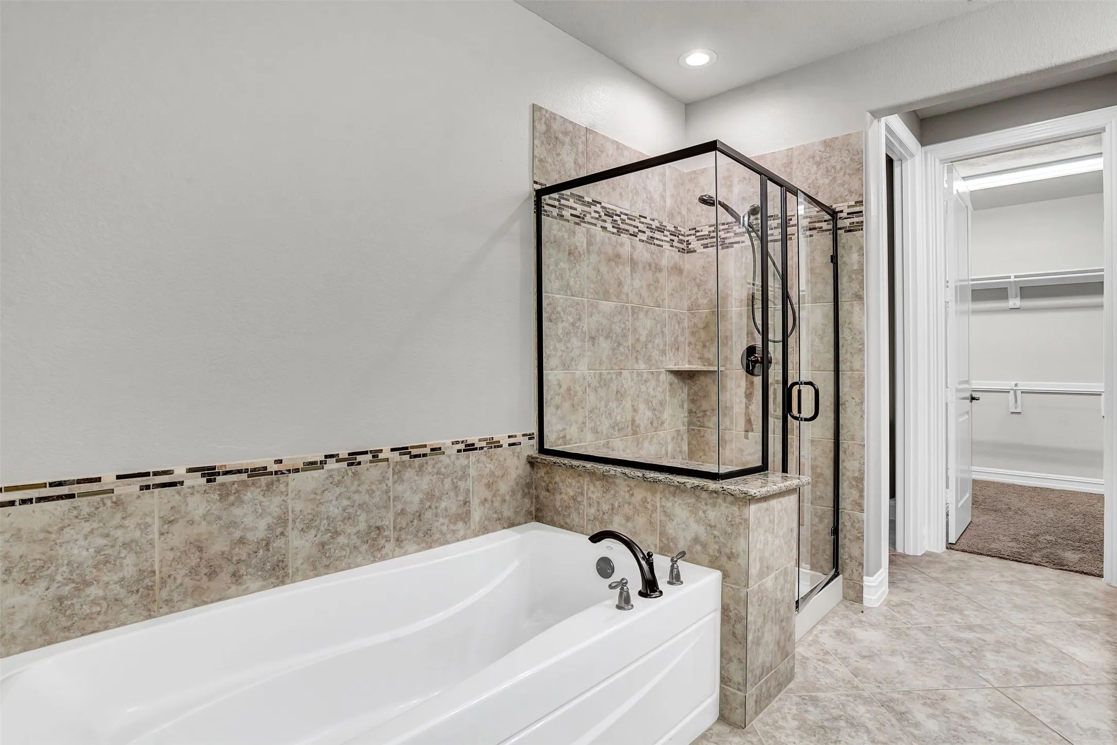 A wonderful separate tub and shower are accented by matching tile and glass tile trim.