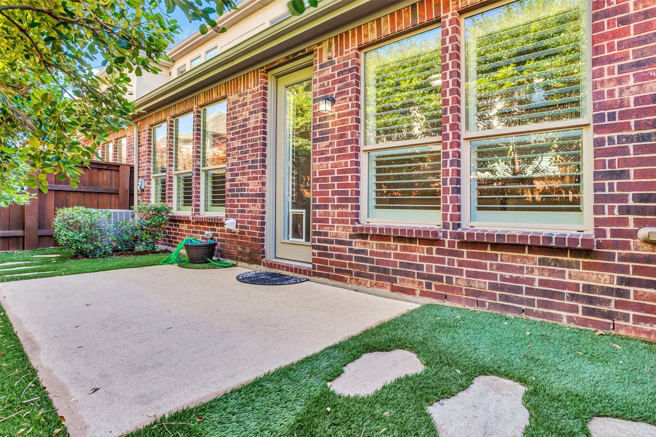 Lovely patio has large stepping stone that take you to the side of the house. You can really appreciate all the windows in the home that keep it so bright inside!
