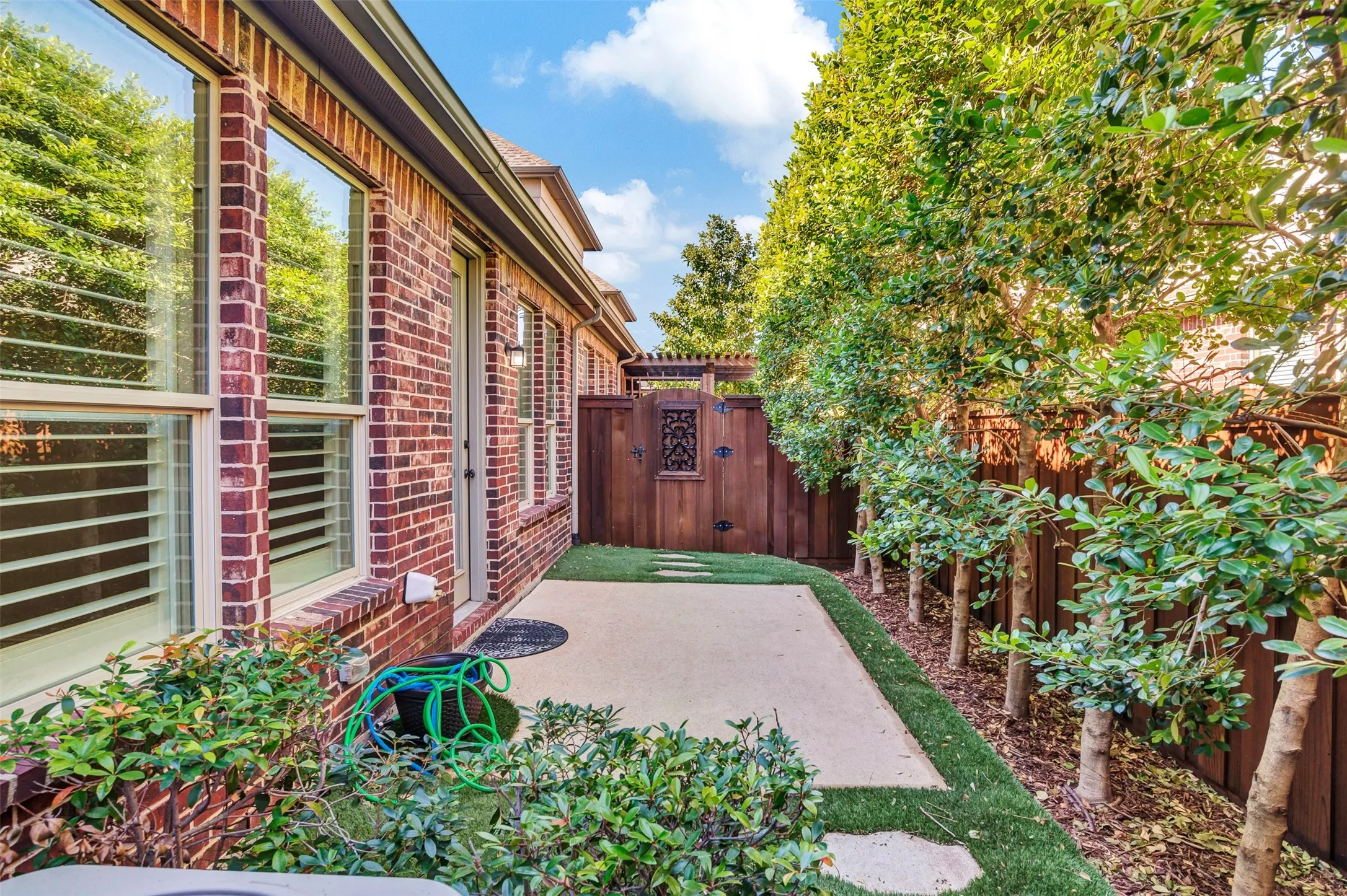 The backyard may be compact, but it's big enough to enjoy! Mature trees keep it private, and artificial turf means you never have to mow or weed or any other lawn maintenance!
