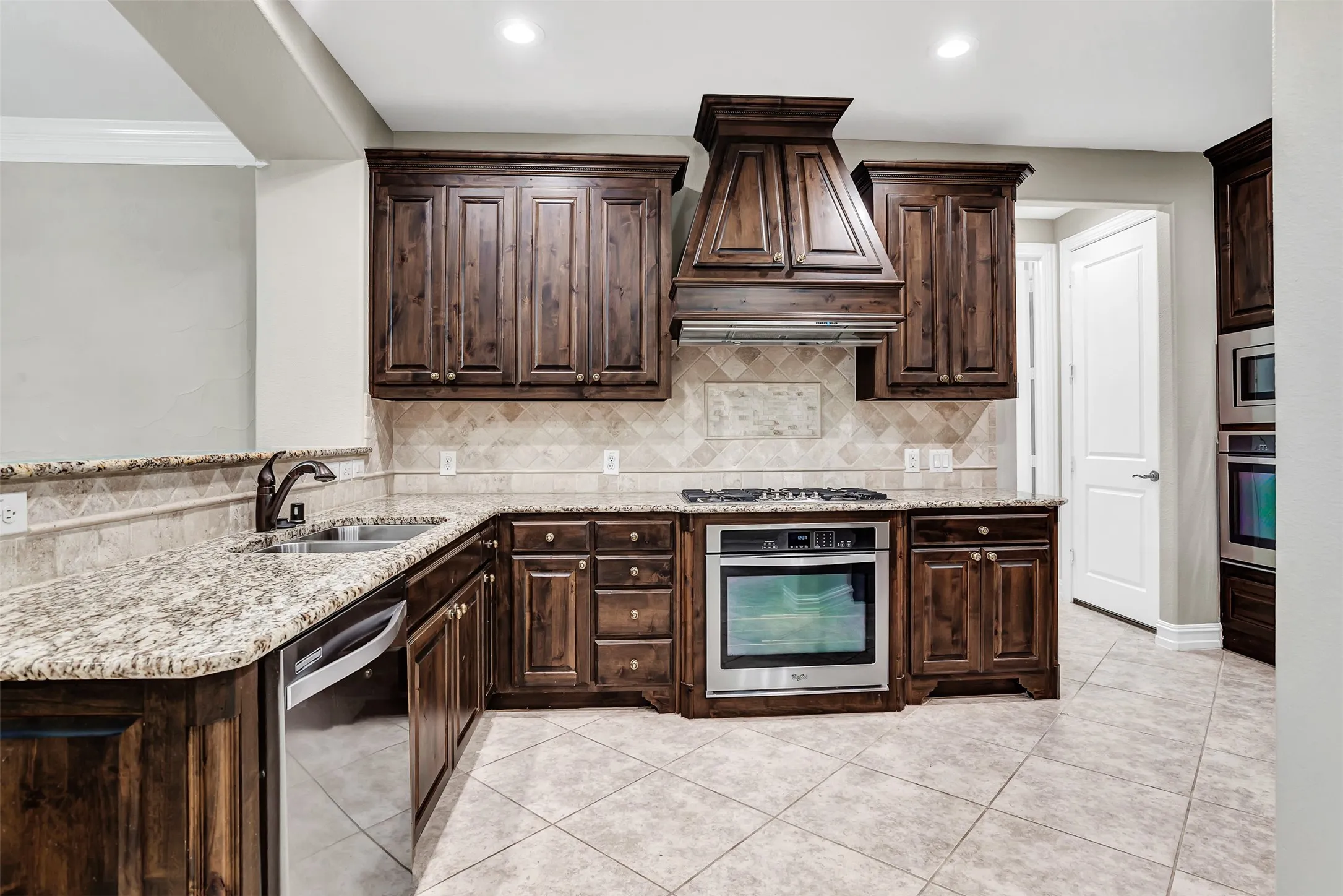 Just inside the foyer you'll get your first glimpse of this magnificent gourmet kitchen! It features a gas cooktop, vent, warm wood cabinets and double ovens!