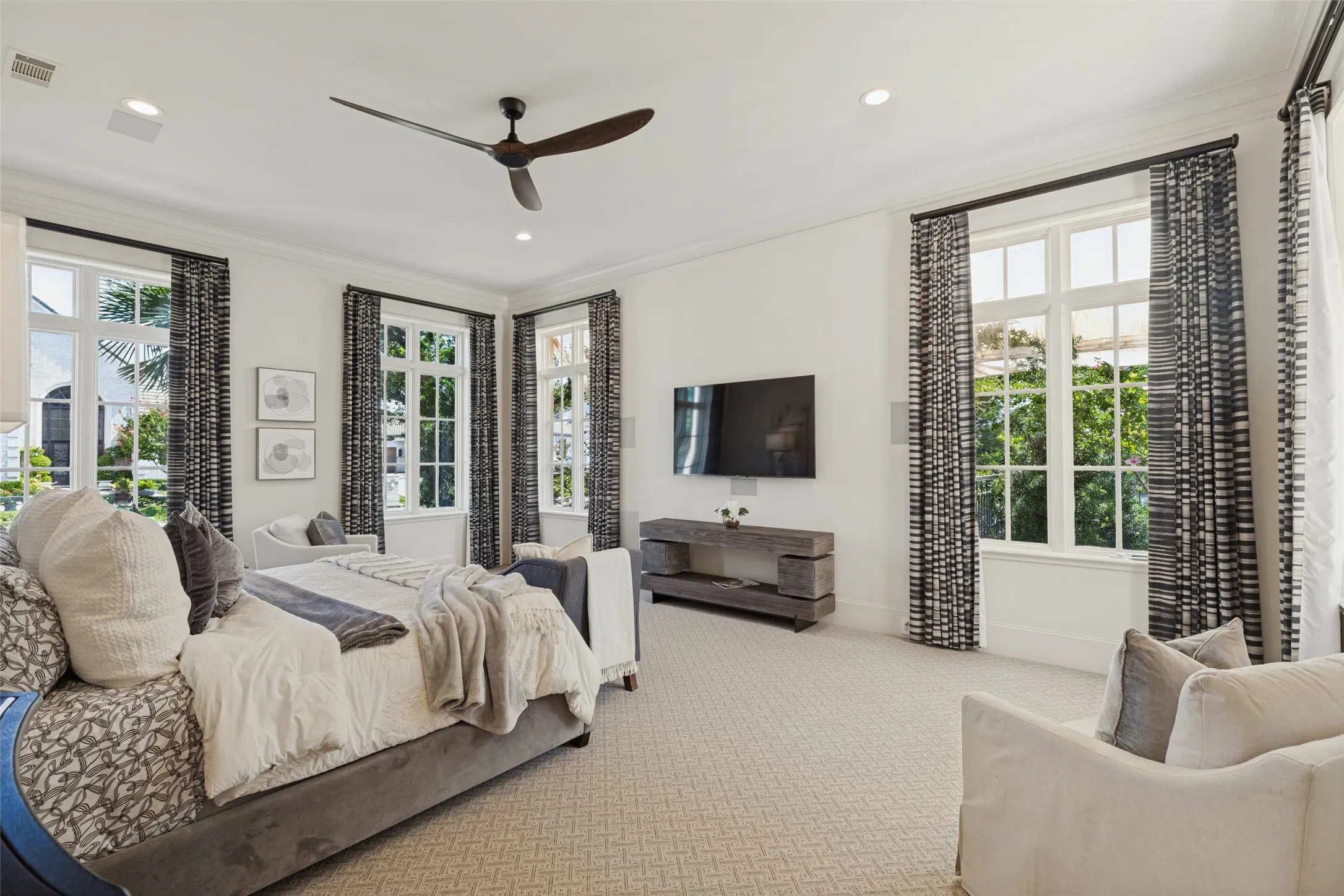 White walls, recessed lighting, and a dark wood-finish ceiling fan