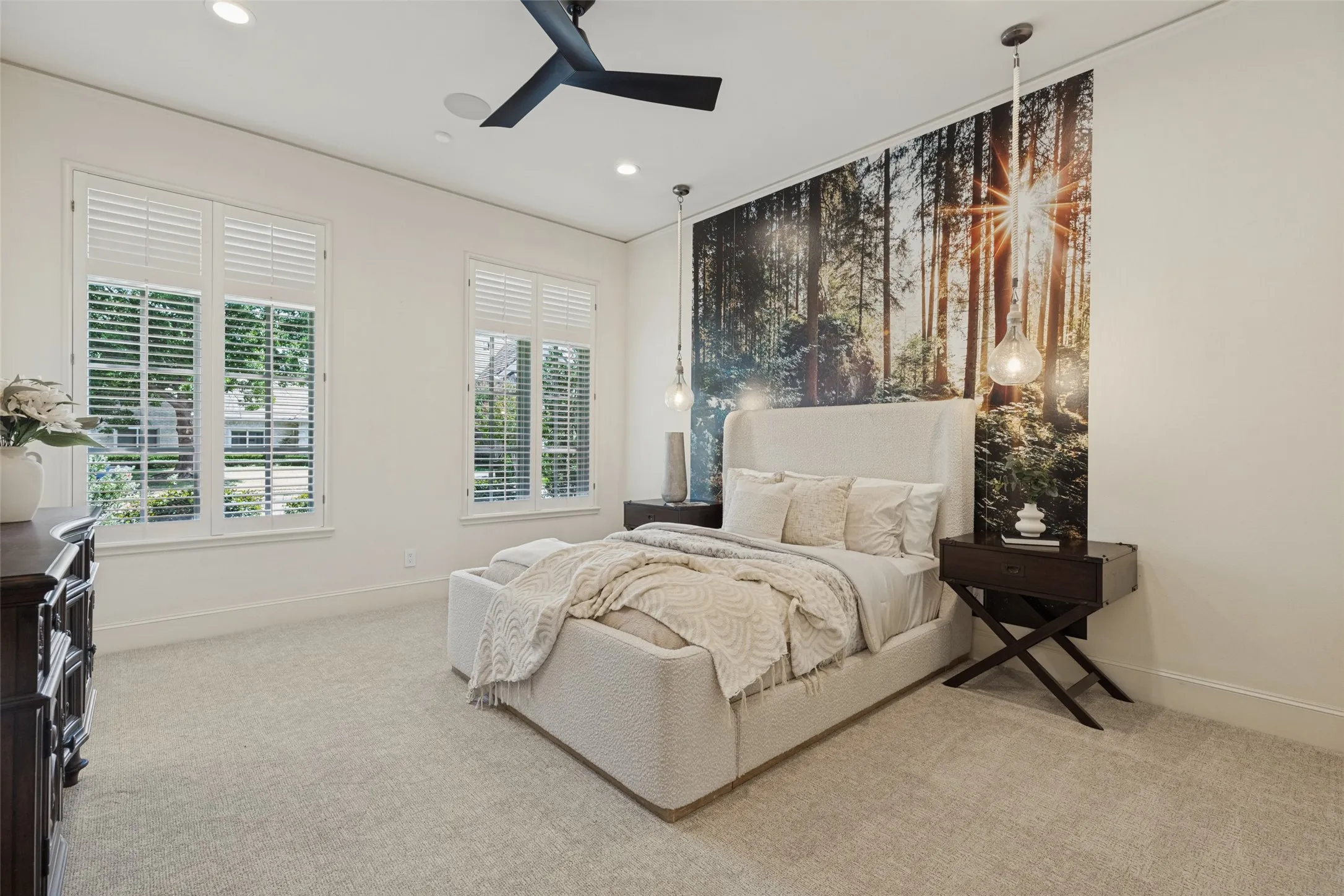 Recessed lighting, ceiling fan, two windows with louvered shutters, accent wall with a wall mural, and two pendant light fixtures