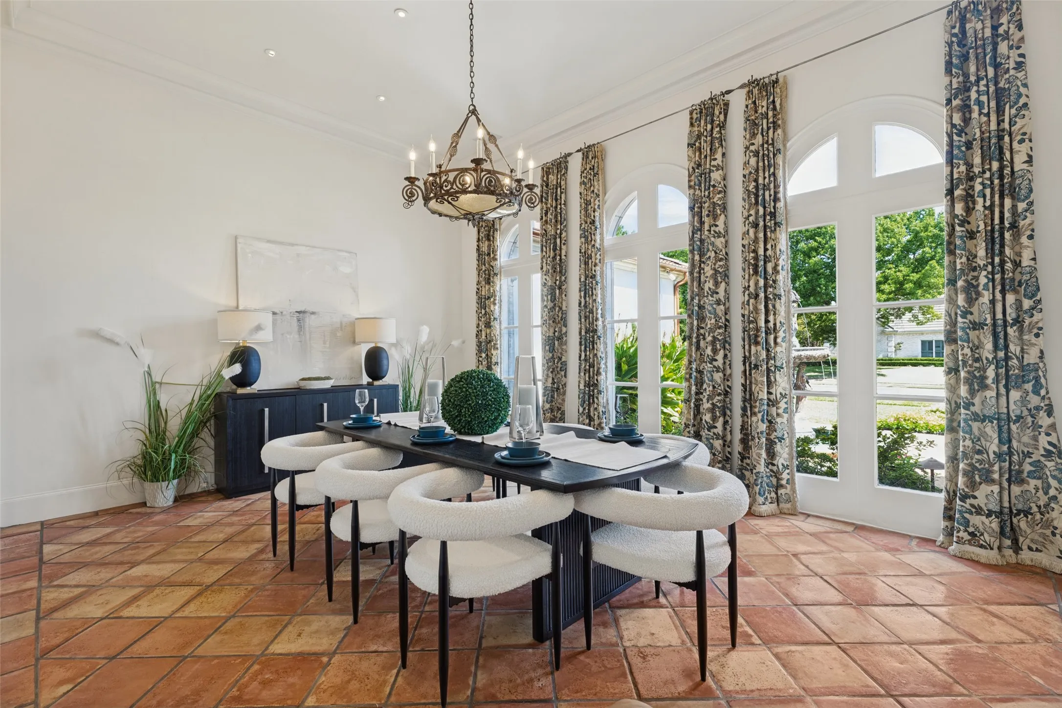 Terracotta tile flooring, arched windows, and a built-in chandelier