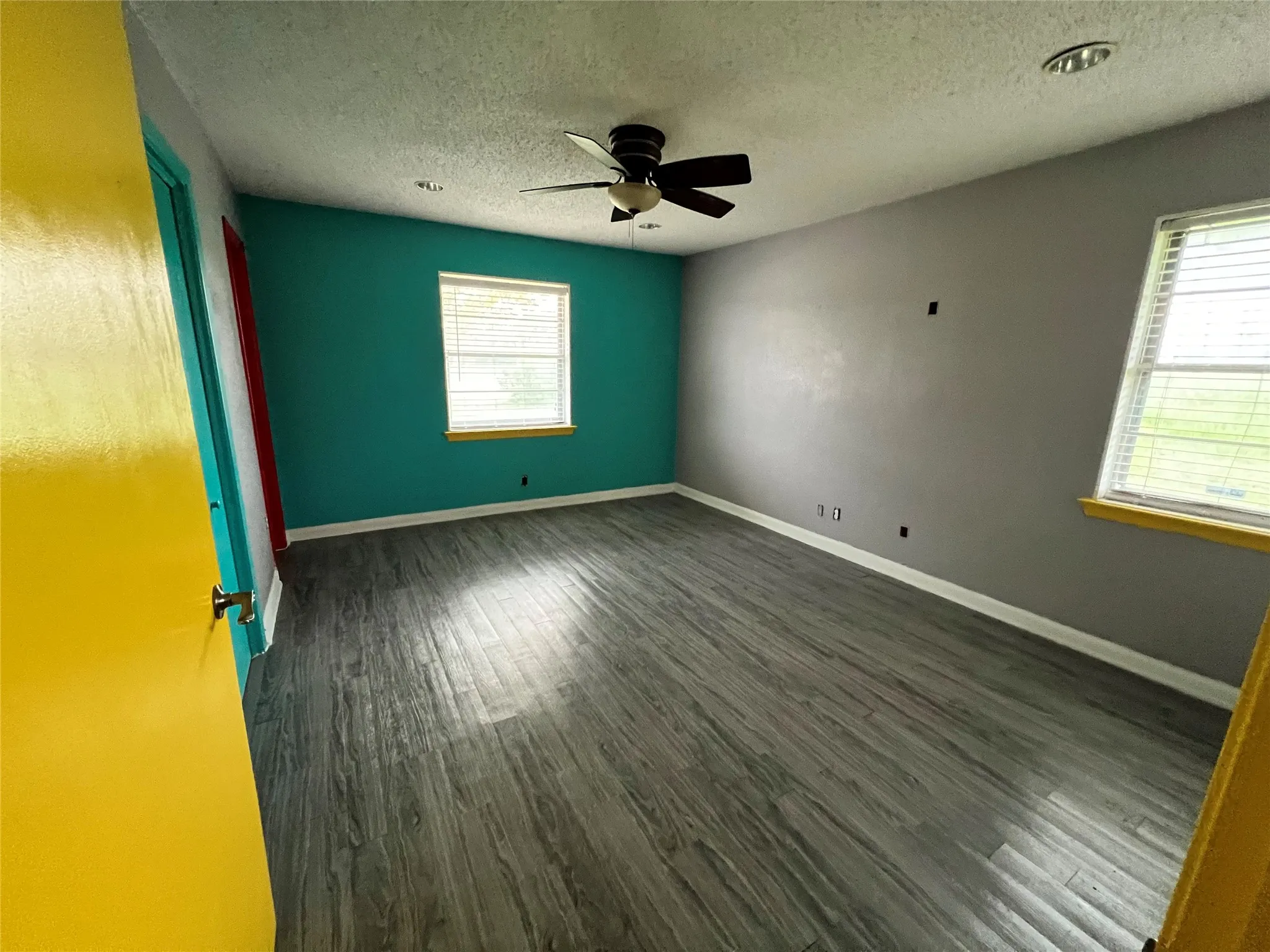 Vinyl flooring, plenty of natural light, ceiling fan, and a textured ceiling