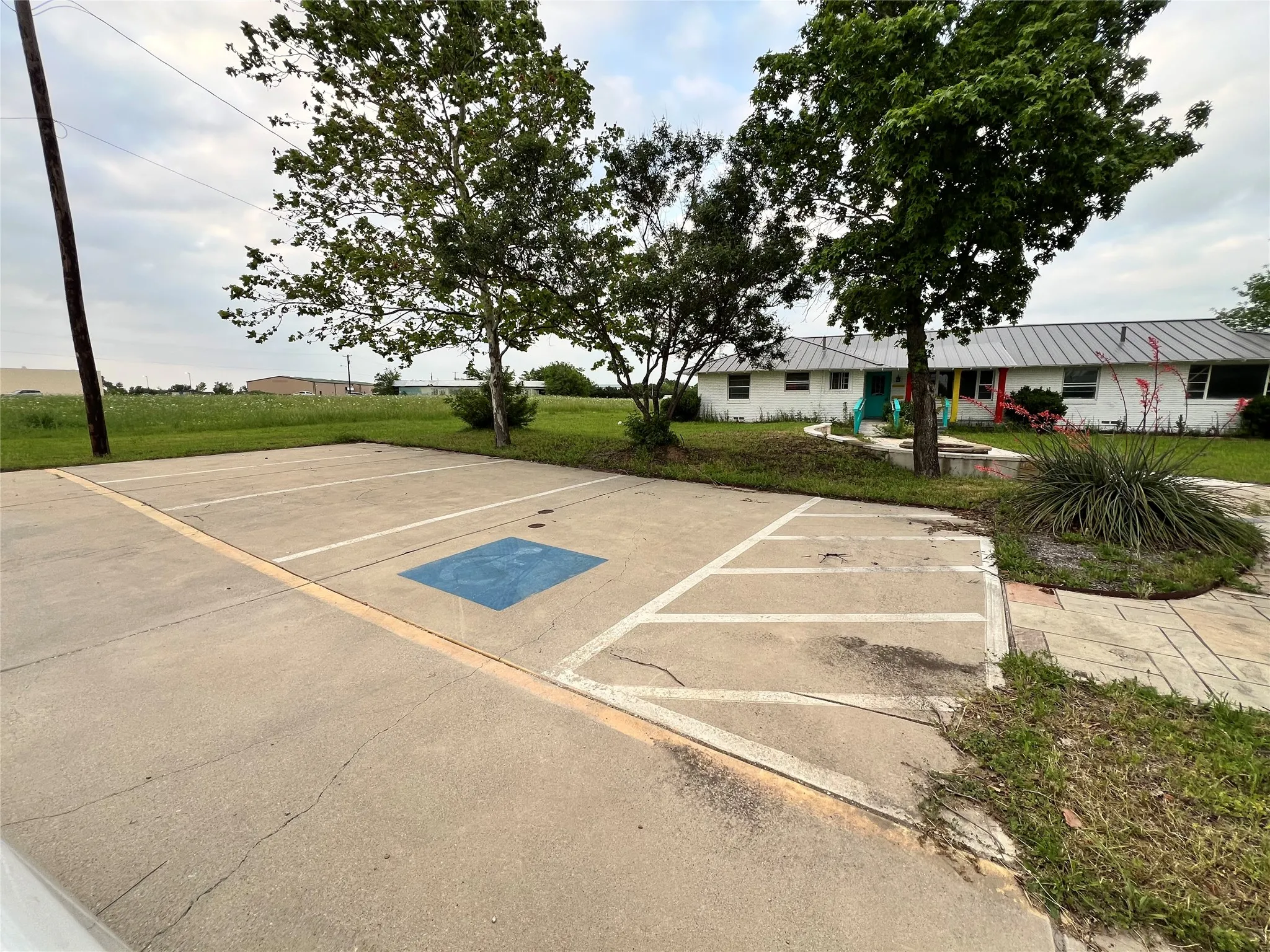 View of parking / parking lot with a lawn