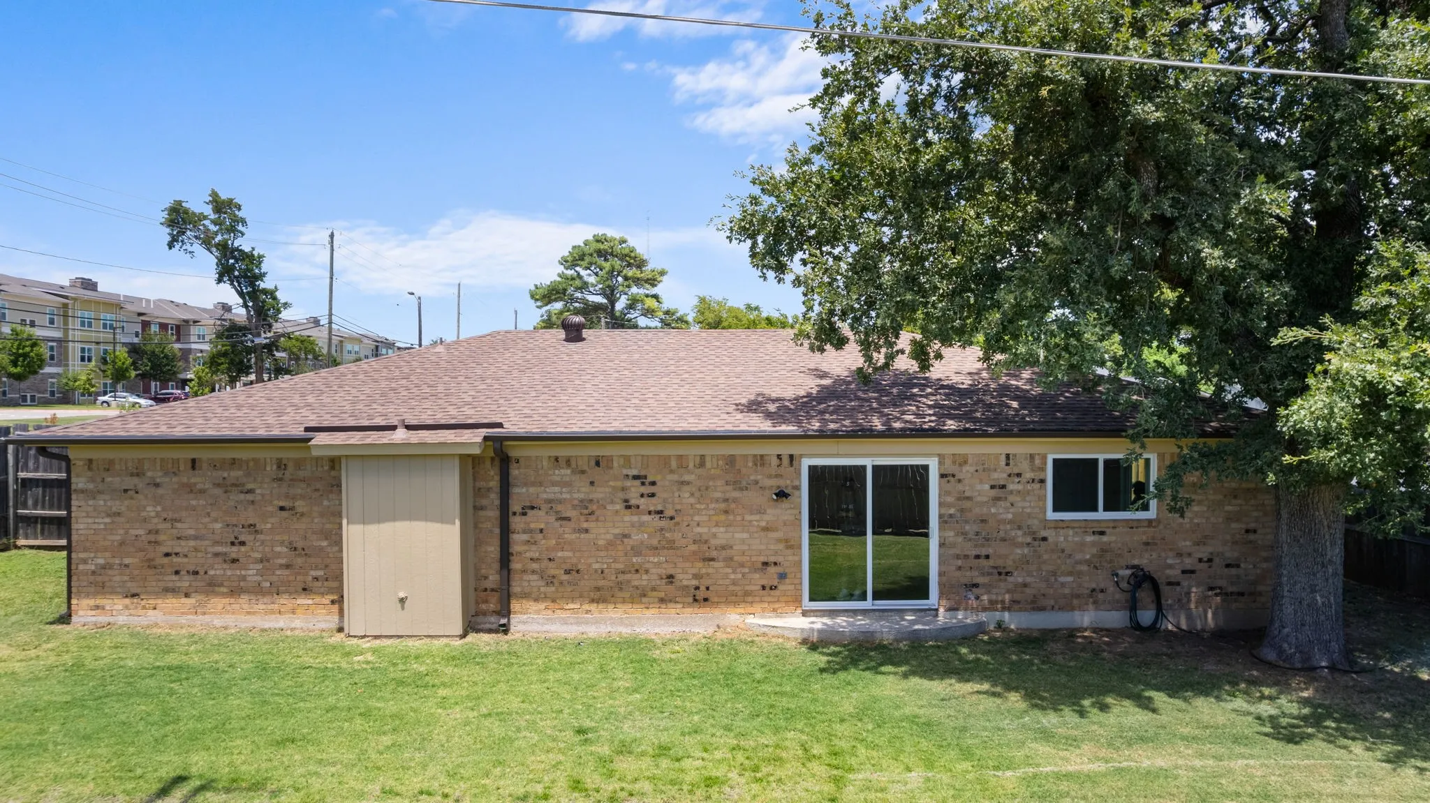 Brick exterior with a brown roof and white gutters