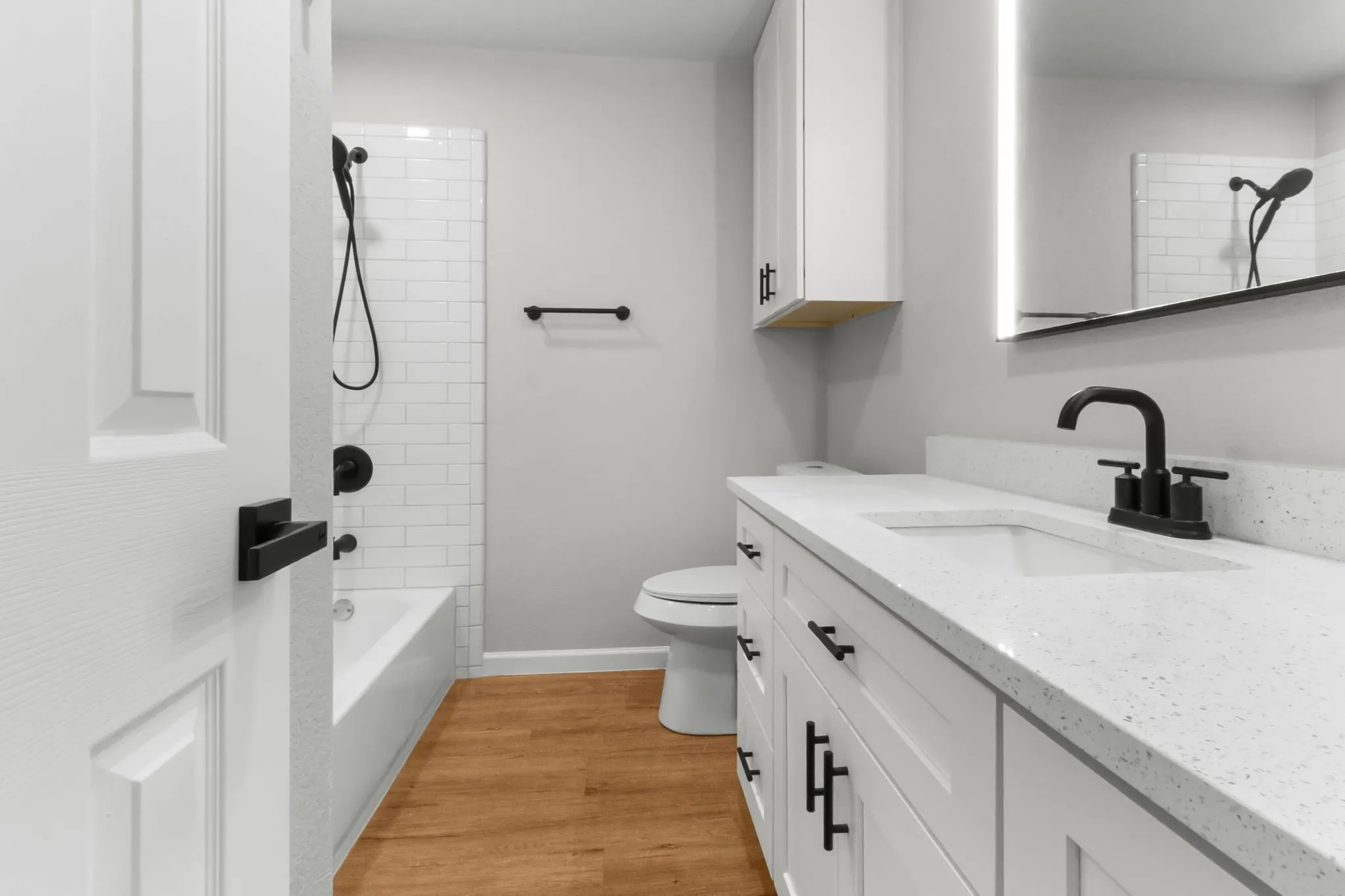 White shaker vanity with matte black hardware, integrated sink, and white countertop