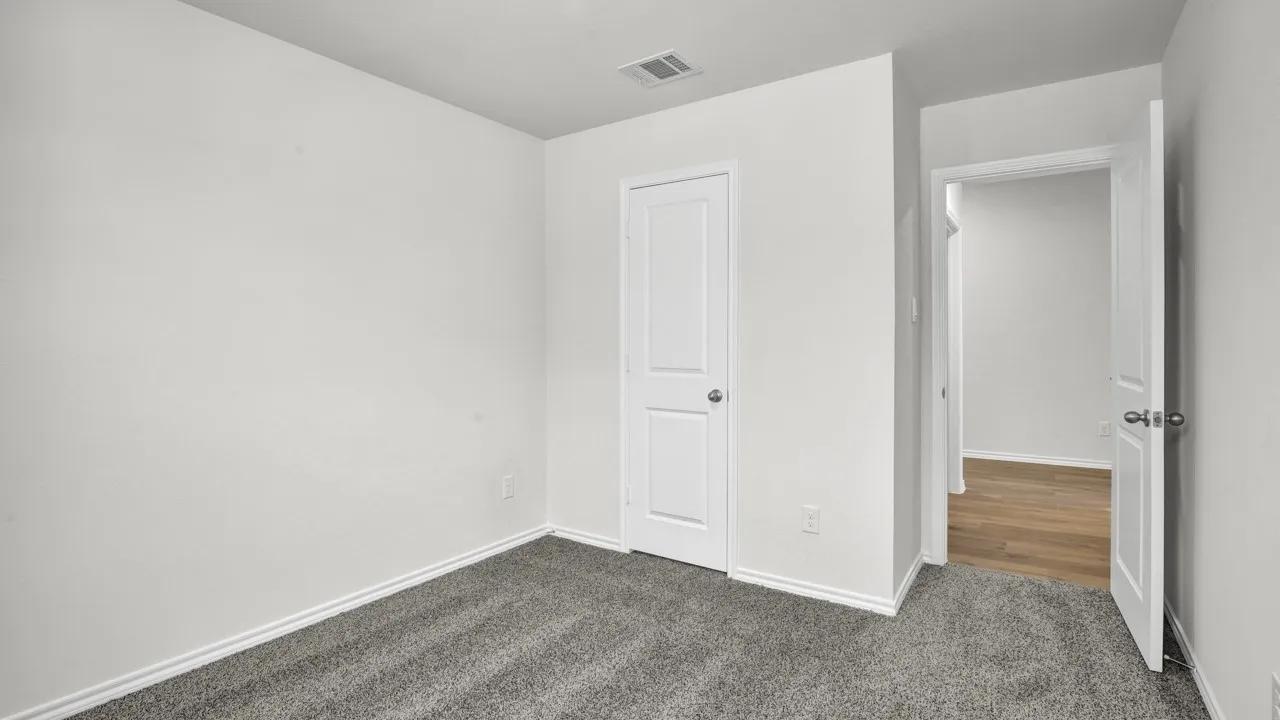 Neutral wall color, carpet flooring, interior panel door, and ceiling air register