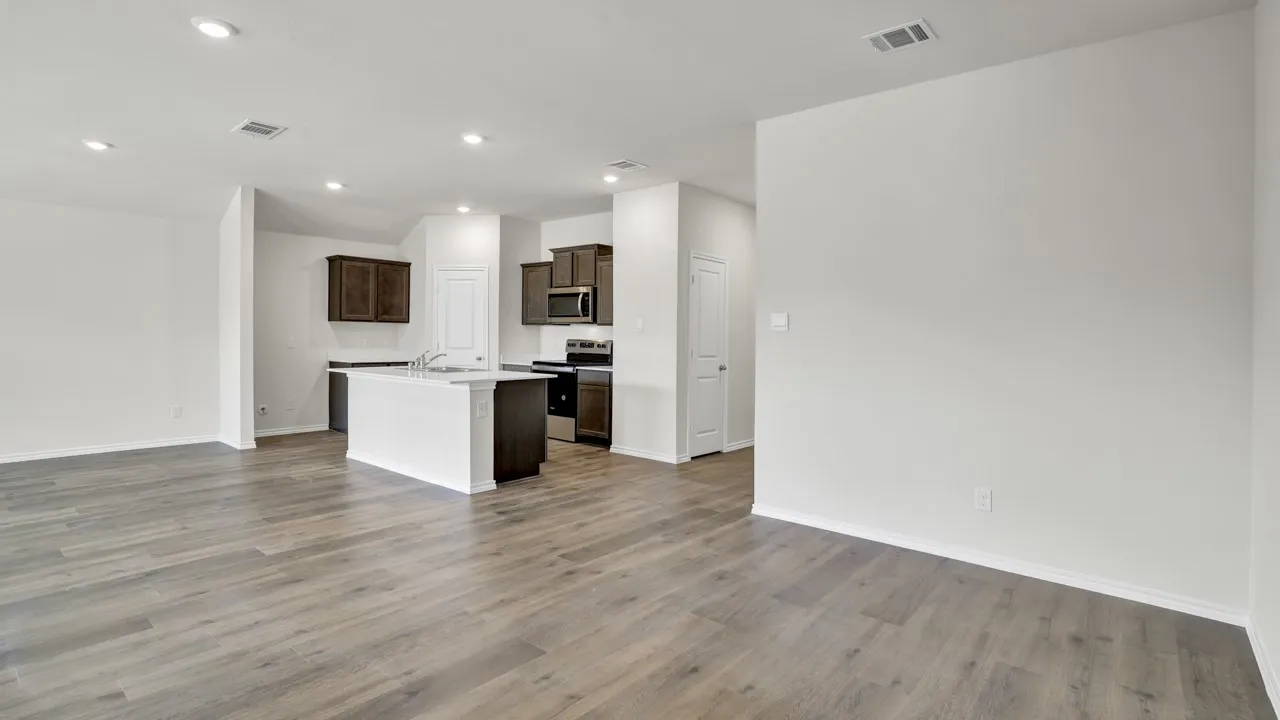 Wood-finish flooring throughout, recessed lighting, and a kitchen island with an integrated sink