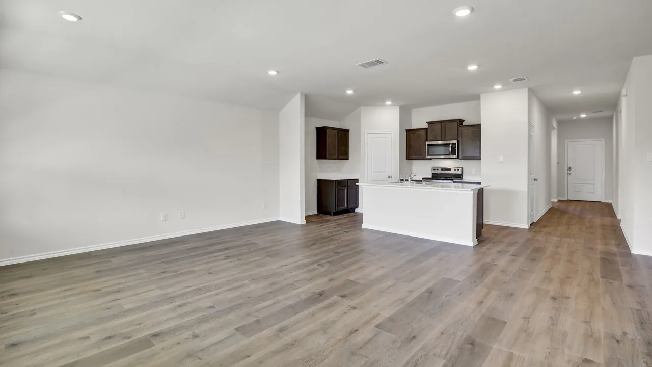 Recessed lighting, wood-finish flooring, dark wood cabinetry, white kitchen island, and stainless steel appliances