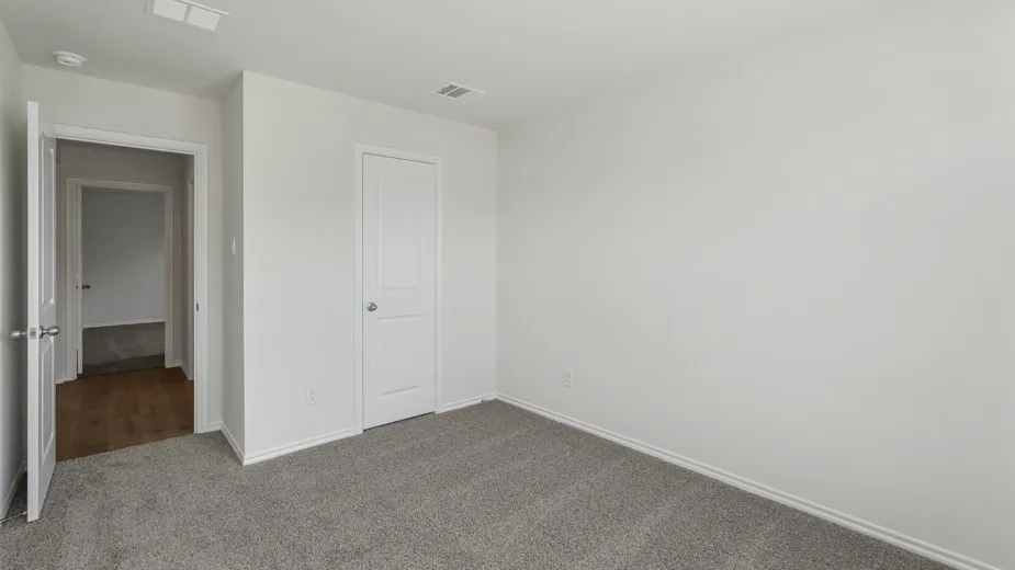 Neutral wall tones, gray carpet flooring, white interior doors, and modern door hardware