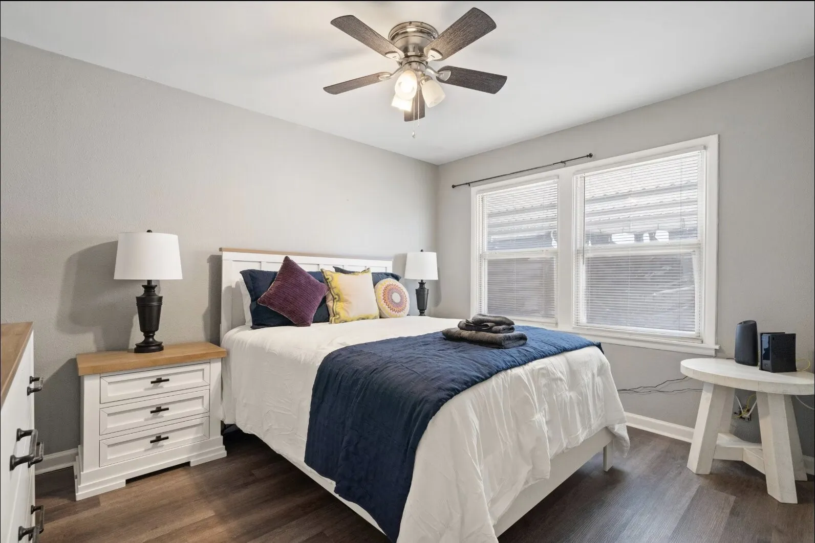 Recessed lighting with a ceiling fan, dual window fixtures, wood-finish flooring, and white trim