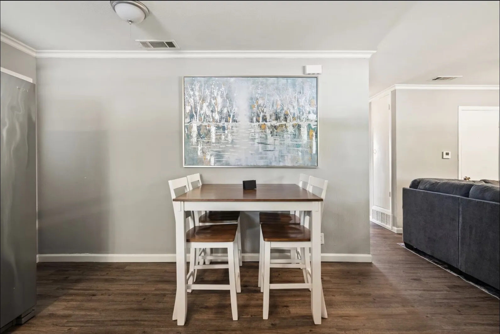 Wood-finish flooring, crown molding, and recessed lighting create a cohesive aesthetic