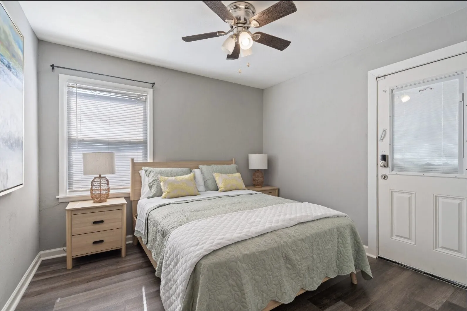 Wood-finish flooring with light gray walls and a ceiling fan
