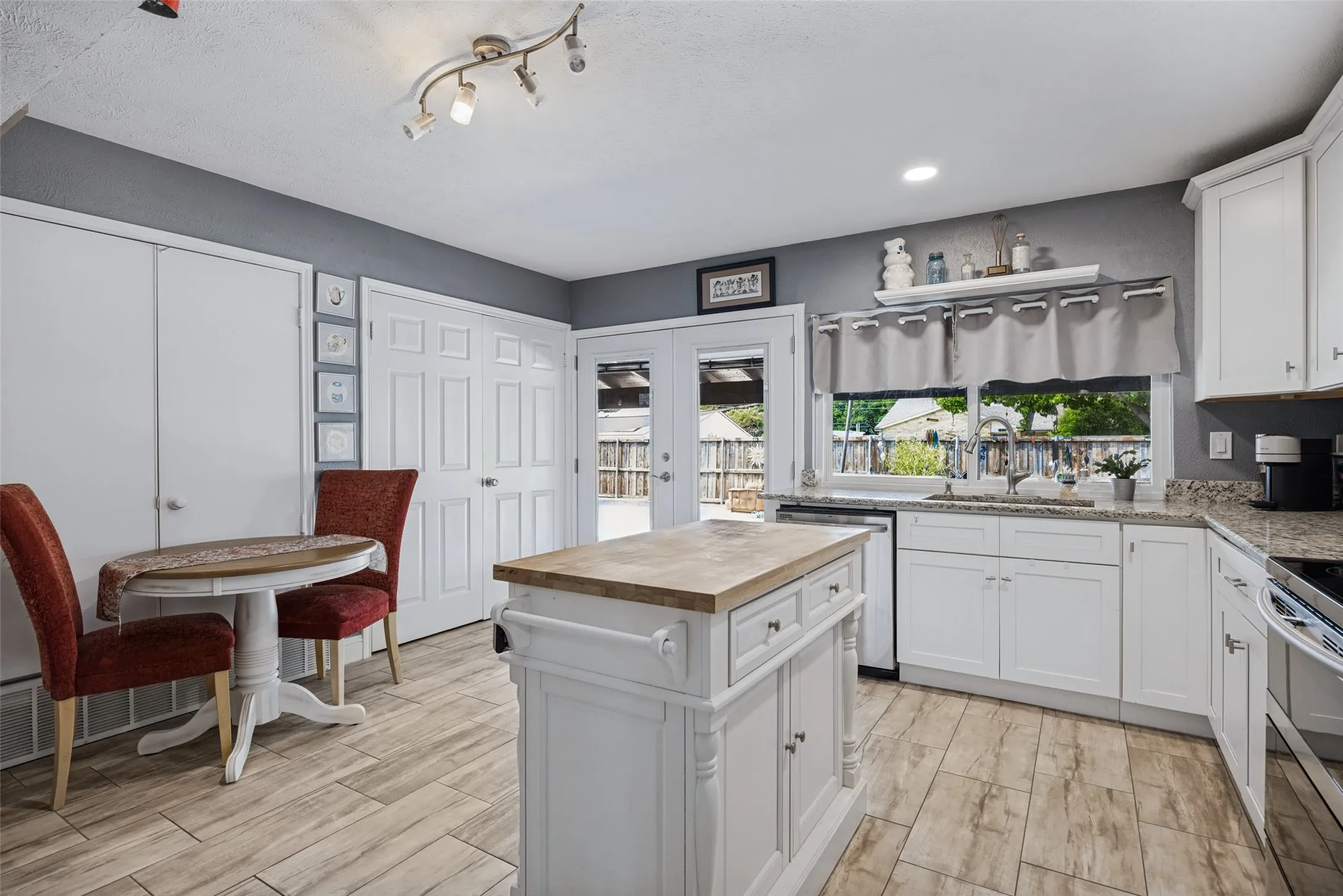 Kitchen featuring white cabinetry, wood-finish flooring, and a central island with a wood-finish countertop