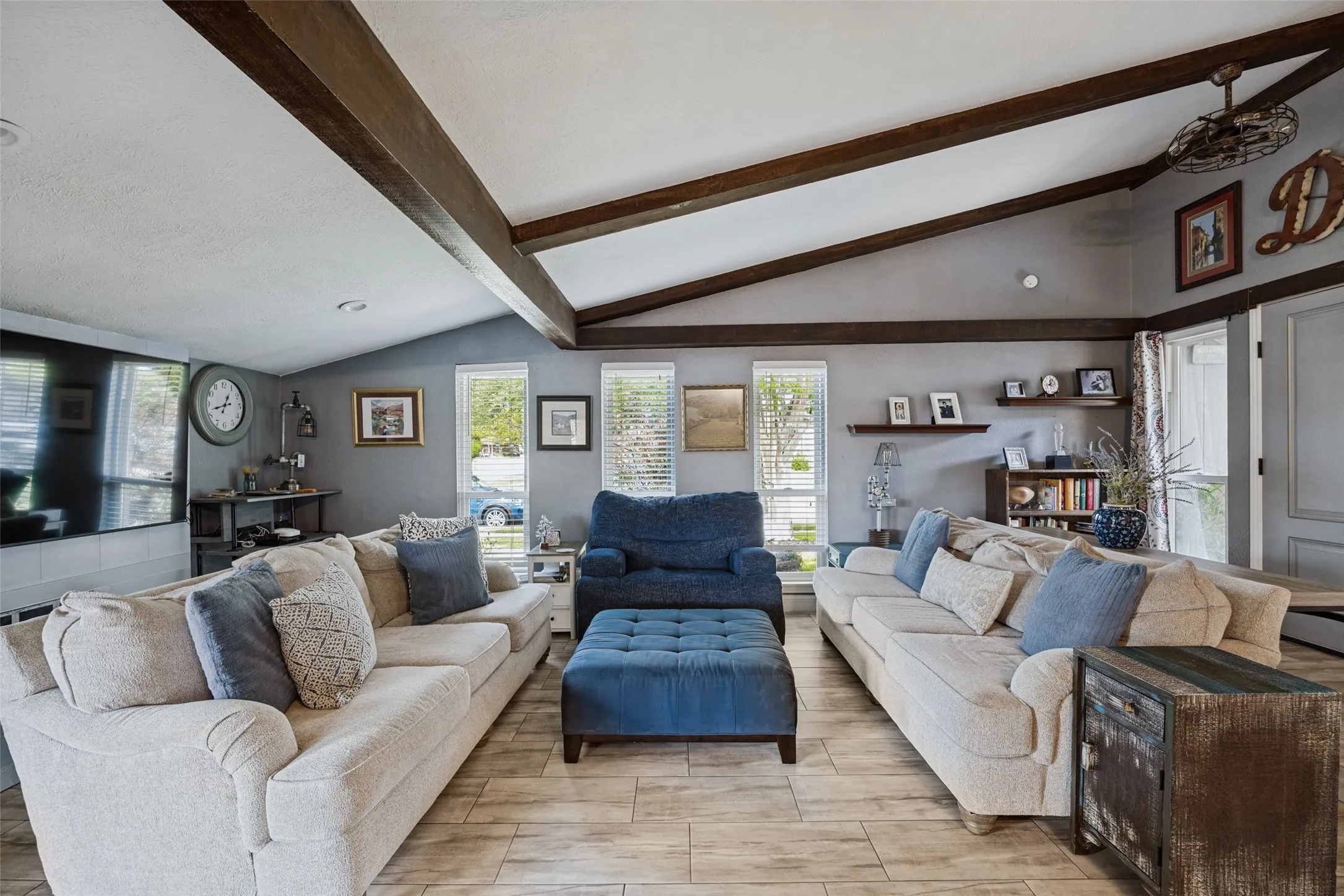 Vaulted ceiling with exposed wood beams, wood-finish flooring, and recessed lighting