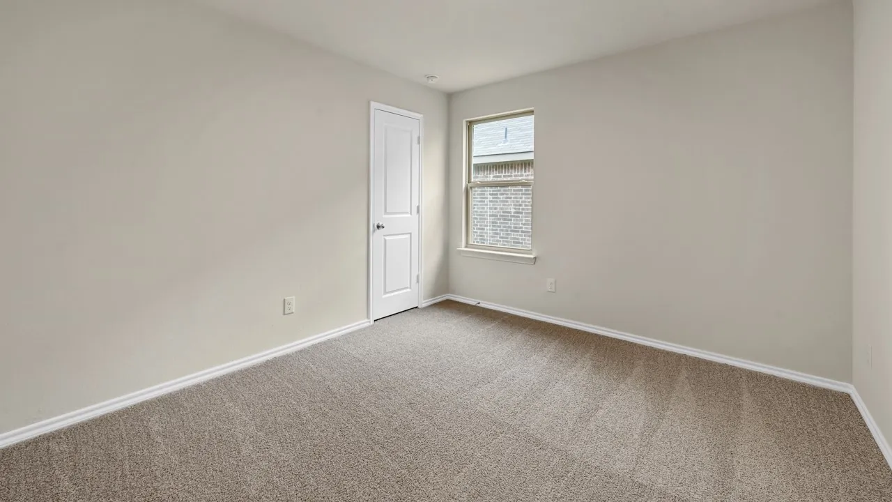 Neutral wall paint, light brown carpeting, white trim, single window, and a white interior door