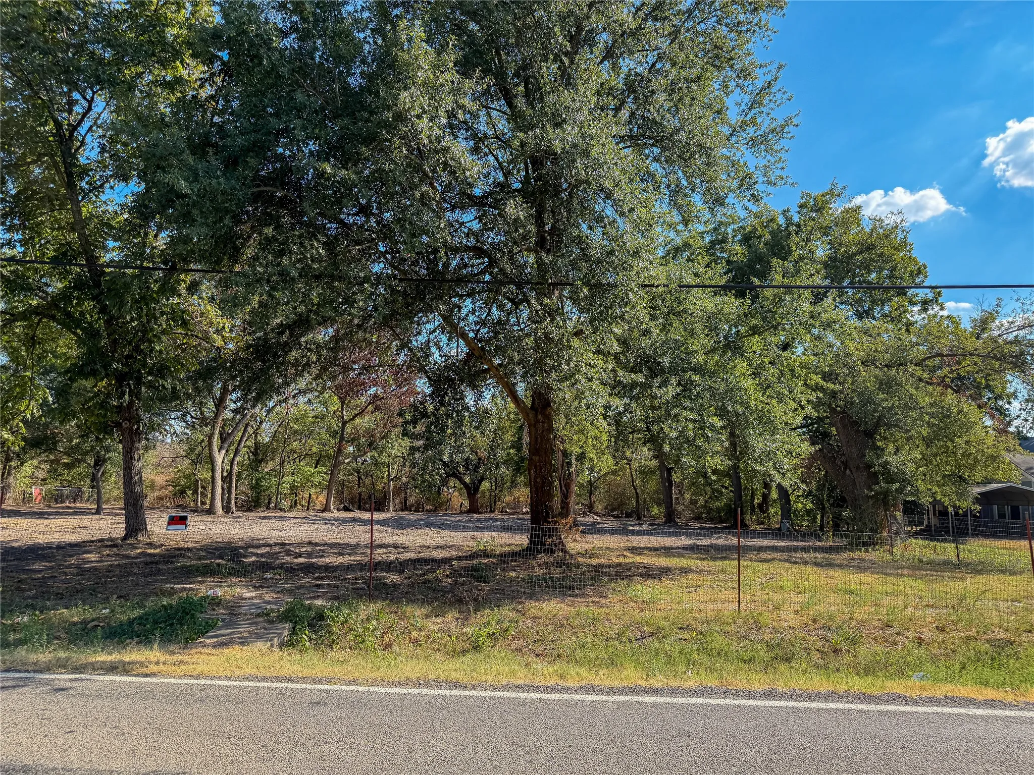 Expansive lot featuring mature trees and a cleared building area