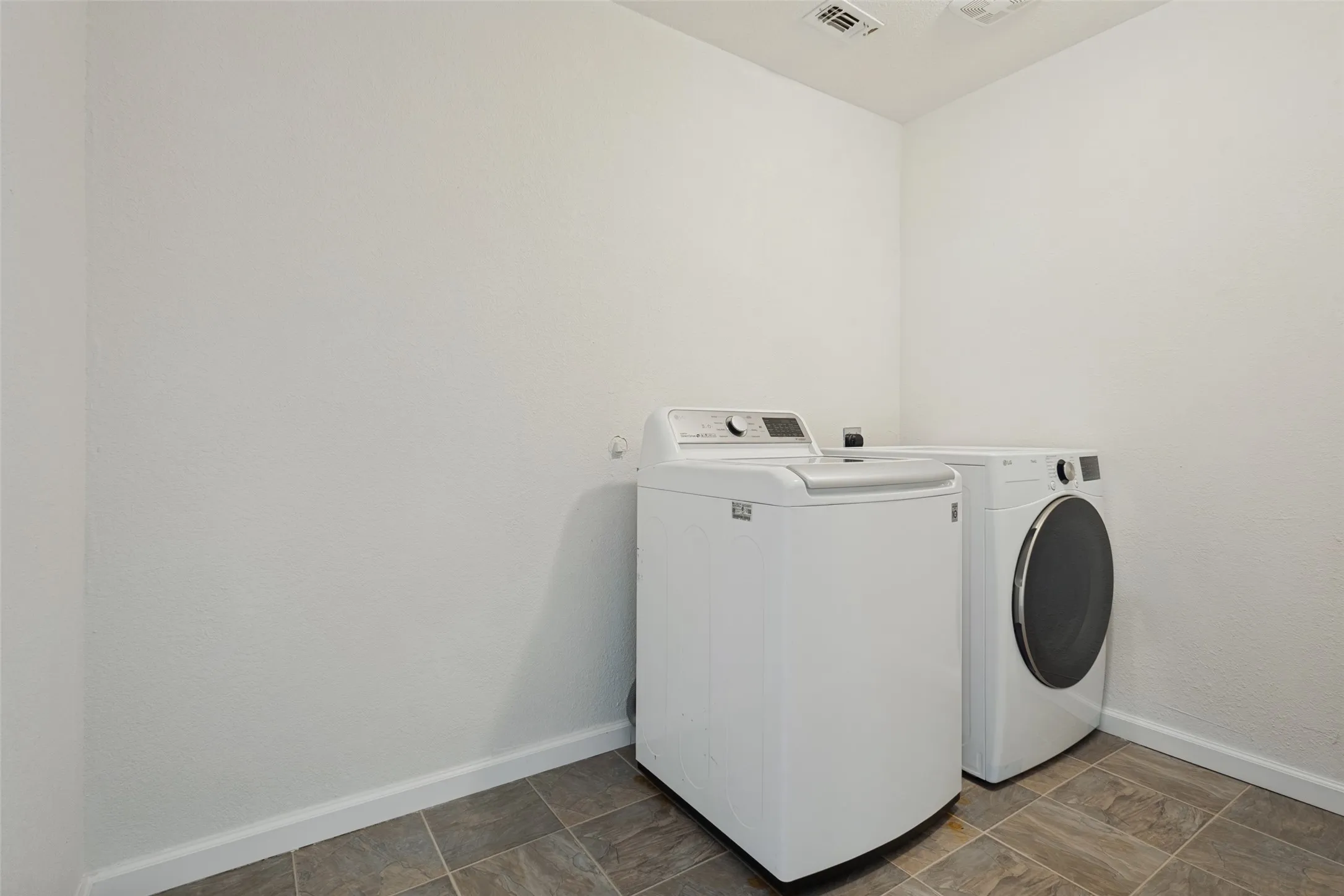 Laundry area featuring tiled flooring and white walls