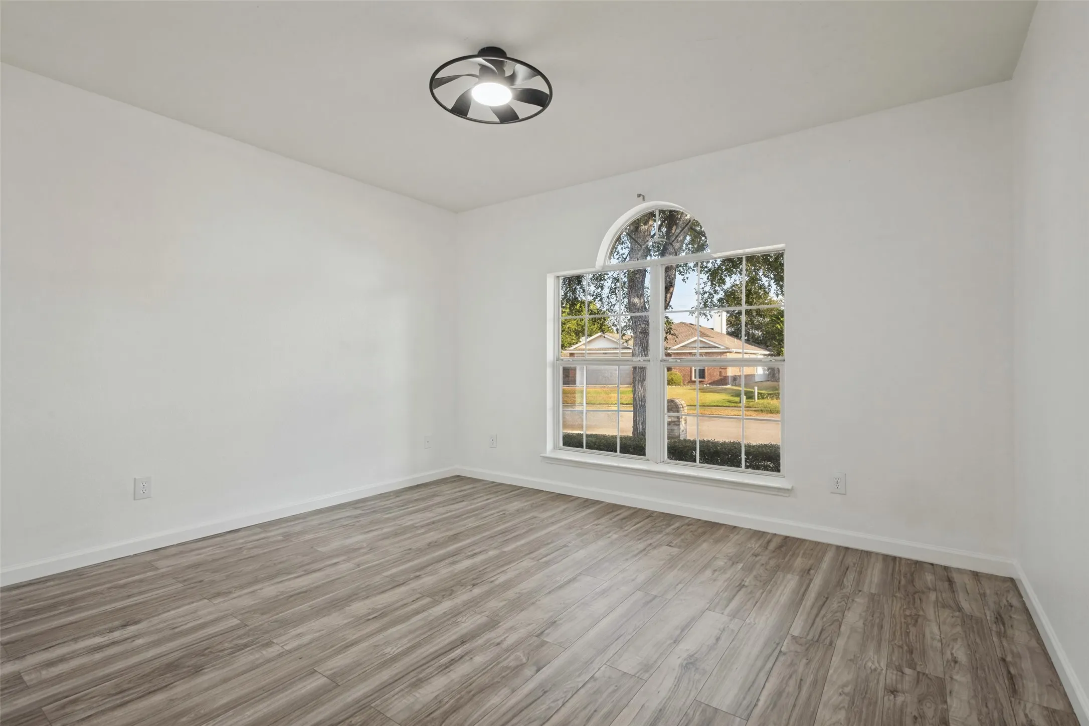 Wood-finish flooring, white walls, and a contemporary ceiling light fixture