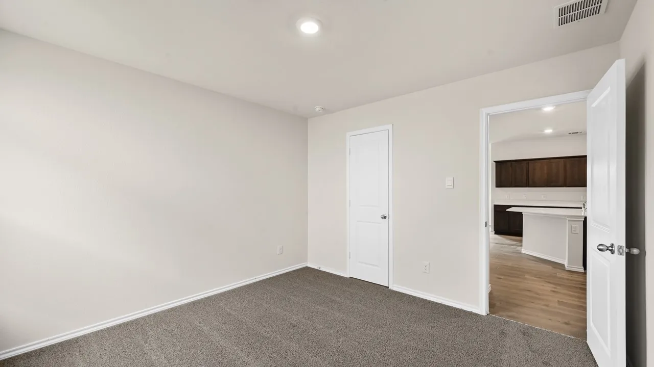 Recessed ceiling lighting, light gray wall paint, gray carpet, white interior door, and wood-finish flooring in the adjacent room