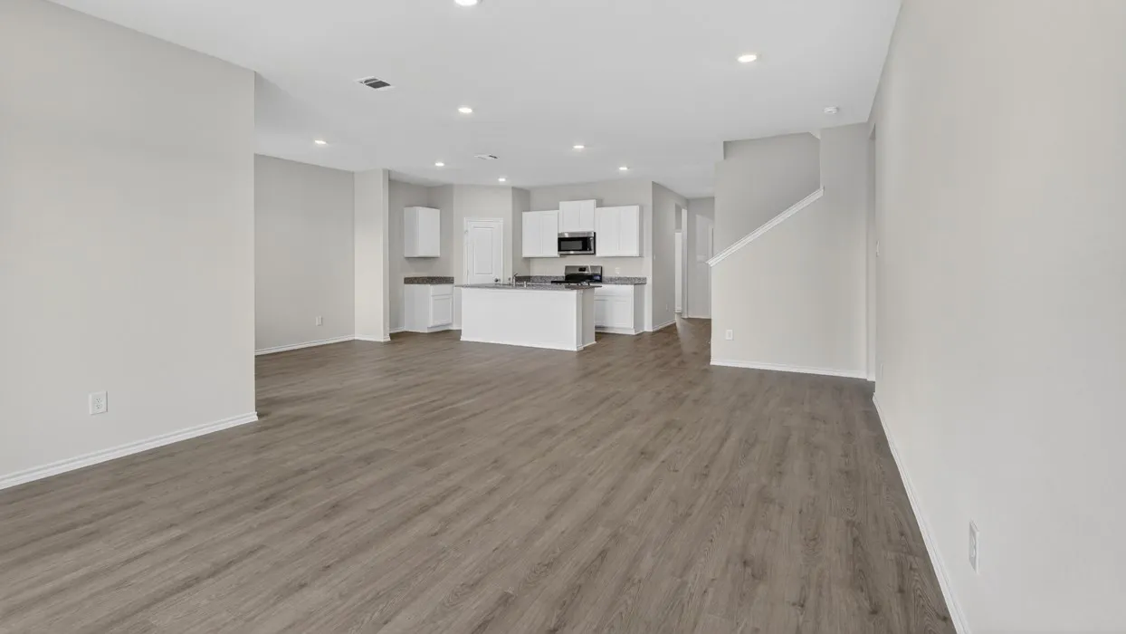 Open concept living area featuring wood-finish flooring, recessed lighting, and a kitchen with white cabinetry and an island