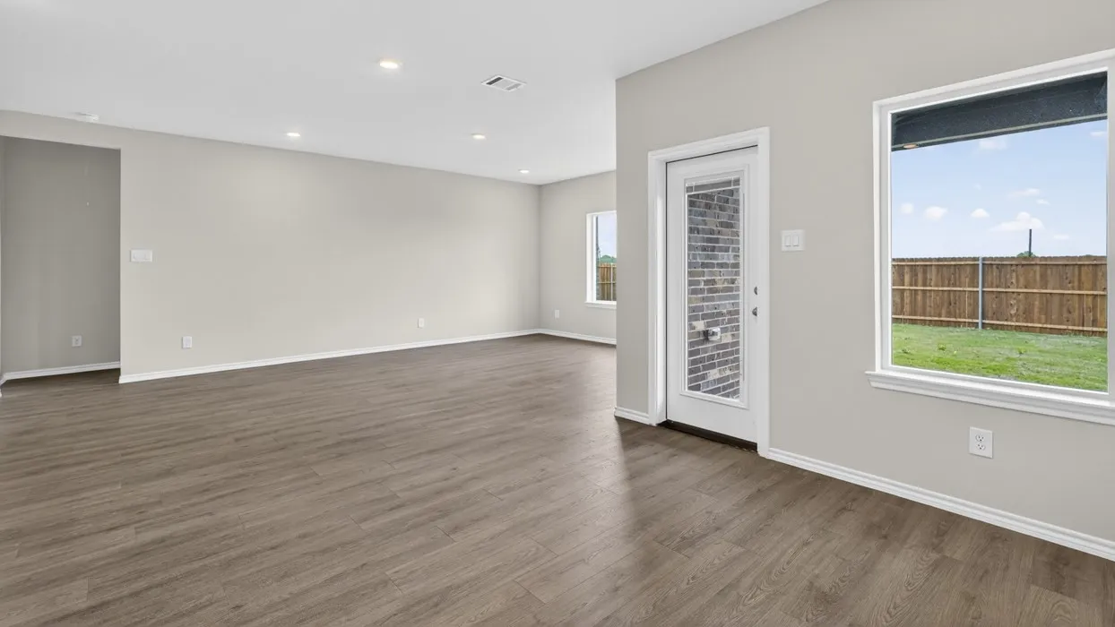 Spacious room featuring wood-finish flooring, recessed lighting, and light-toned walls