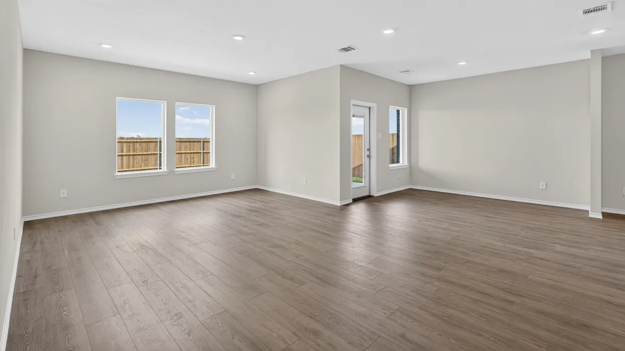 Expansive open-concept room featuring wood-finish flooring, recessed lighting, and multiple windows