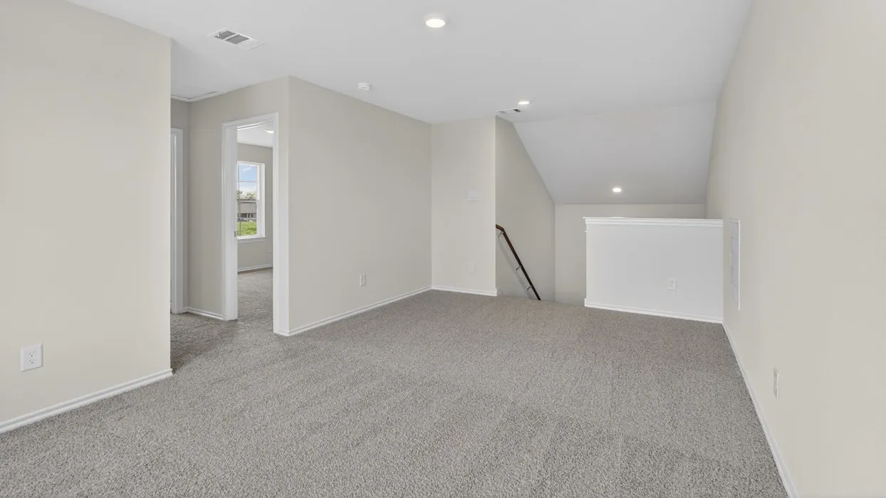 Spacious carpeted room featuring recessed lighting, painted walls, and an open doorway
