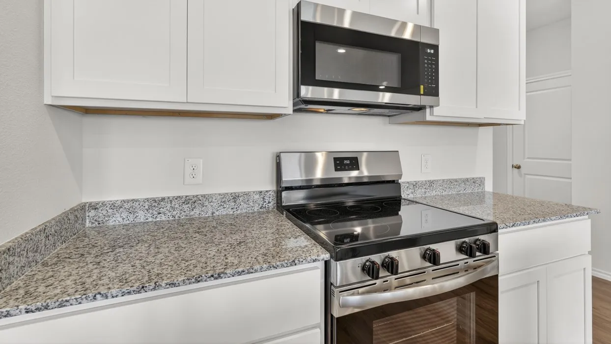 White cabinetry, stainless steel microwave, electric range, and granite-style countertops