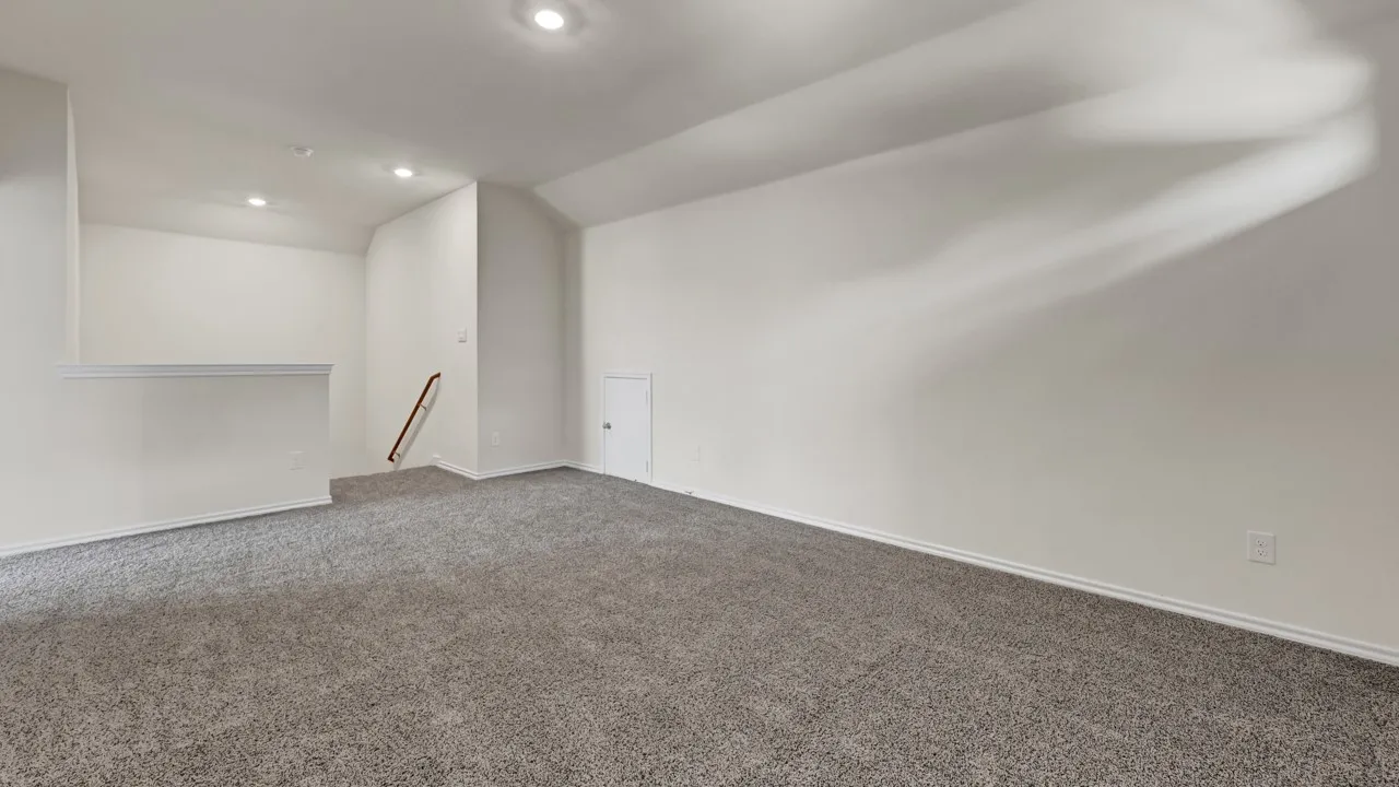 Vaulted ceiling, recessed lighting, neutral tone carpet, white wall finish, and a built-in access panel