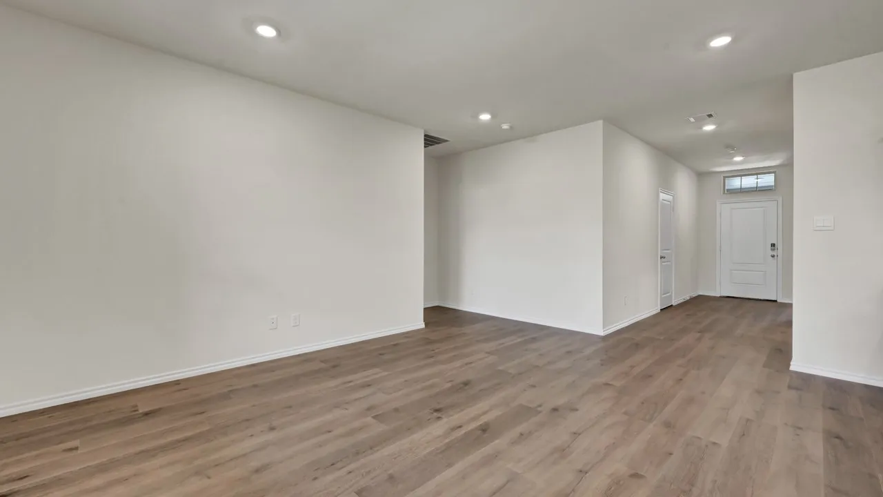 Recessed lighting, wood-finish flooring, and a paneled entry door with transom window