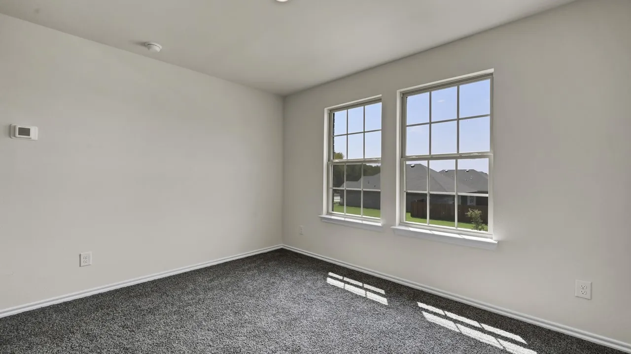 White walls, gray carpeting, and two double-hung windows